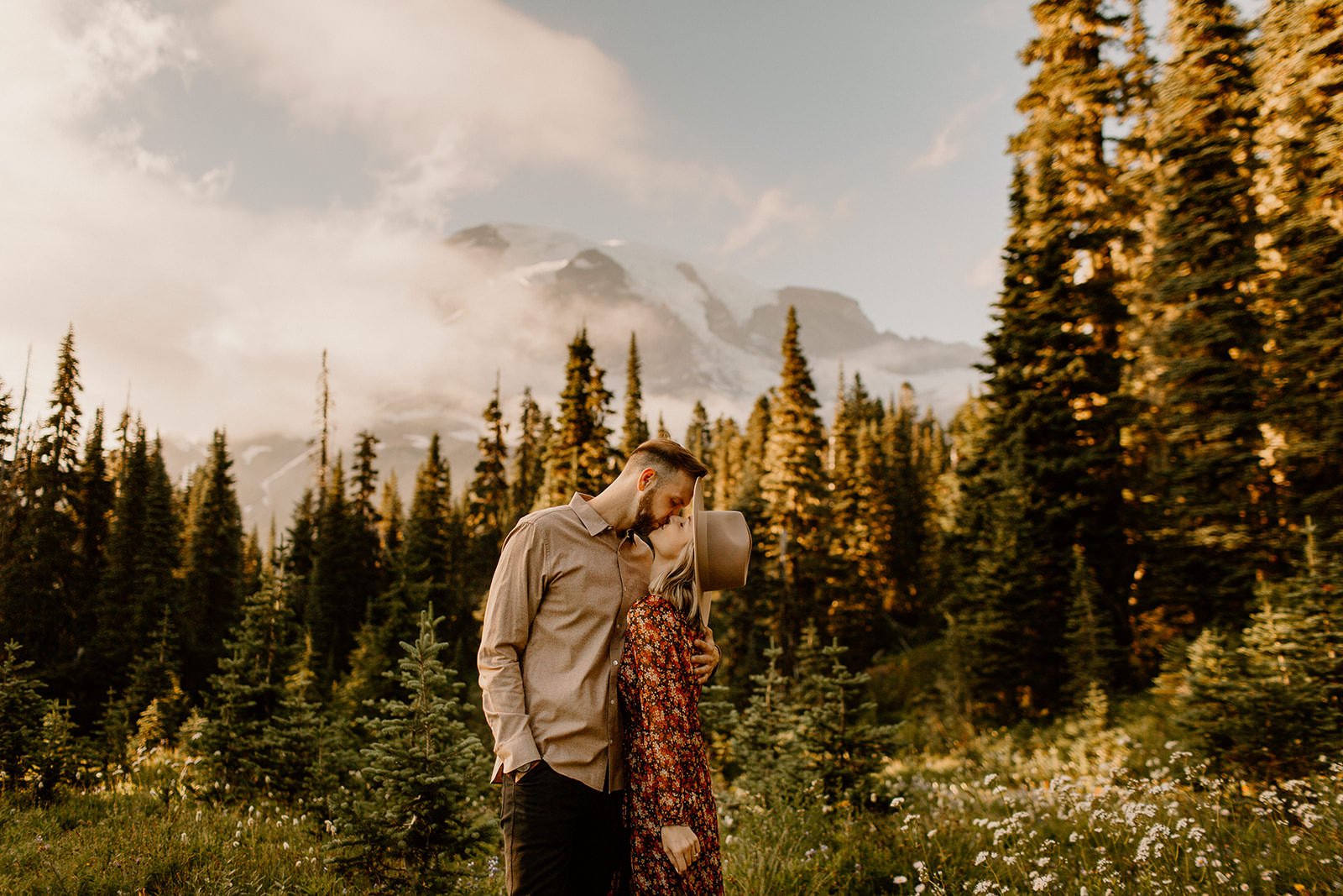 couple kissing in front of mt. rainier peak
