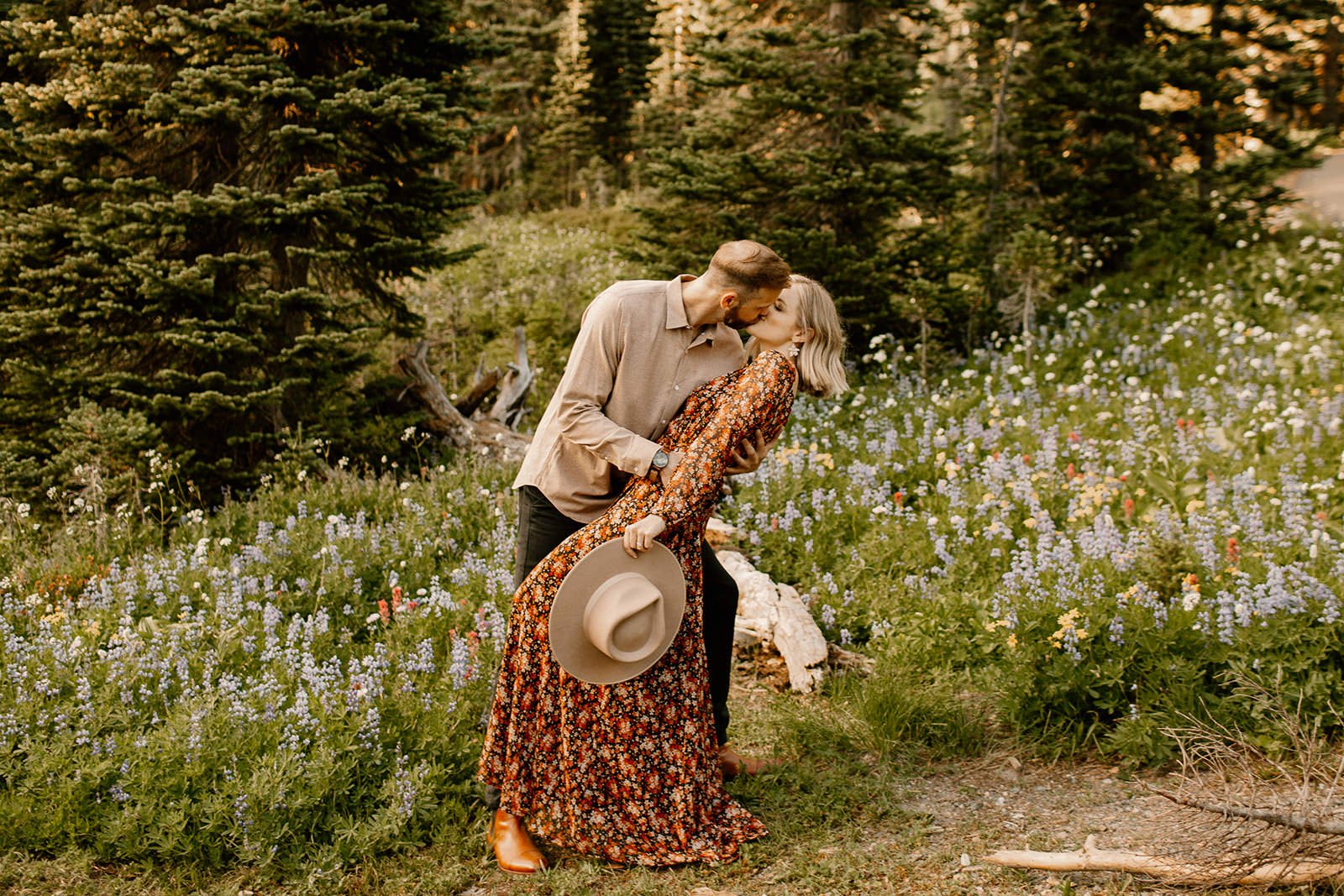 fiance dipping his girlfriend while kissing her in a meadow of wildflowers