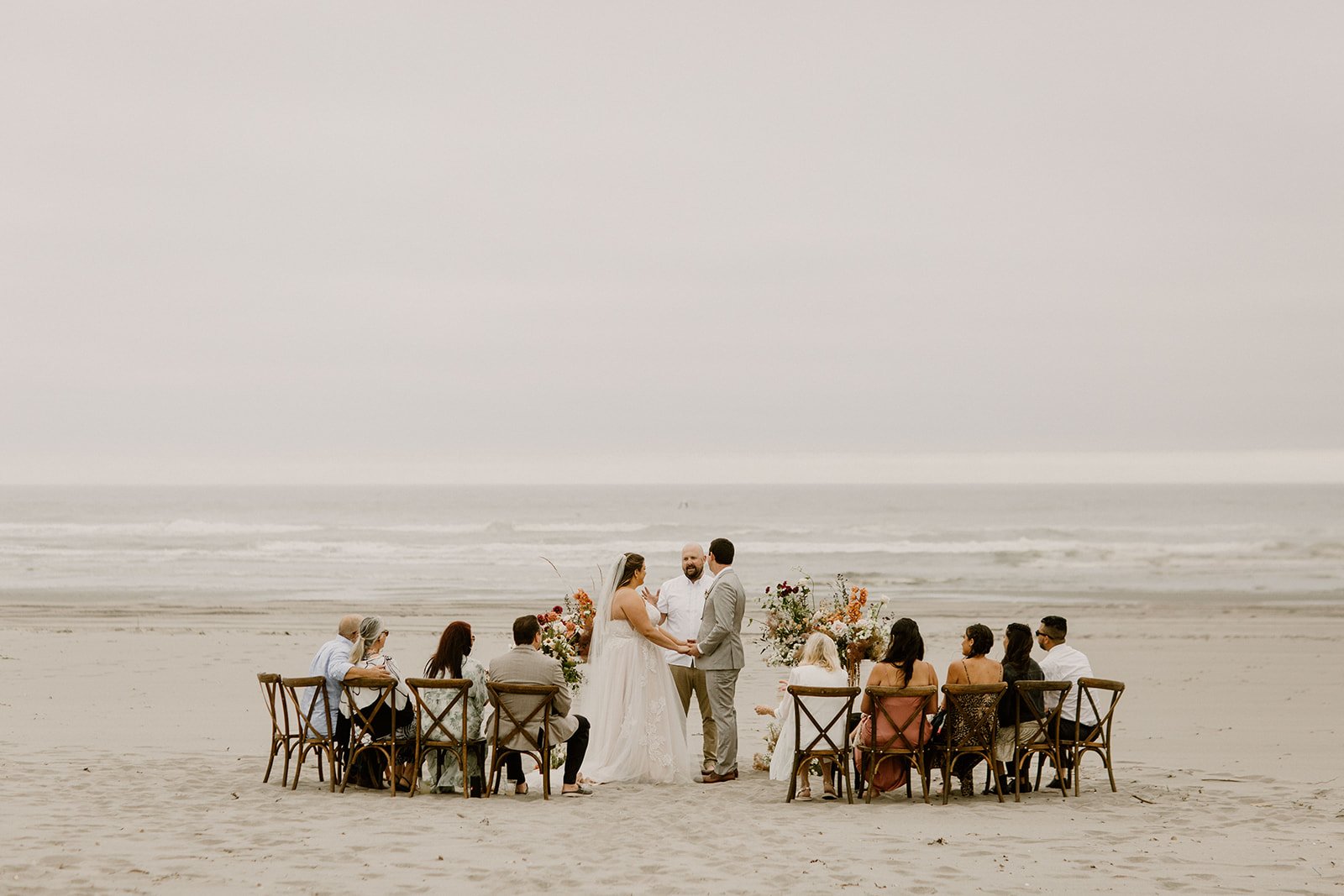 bride and groom holding hands at the alter on a beach in coastal washington