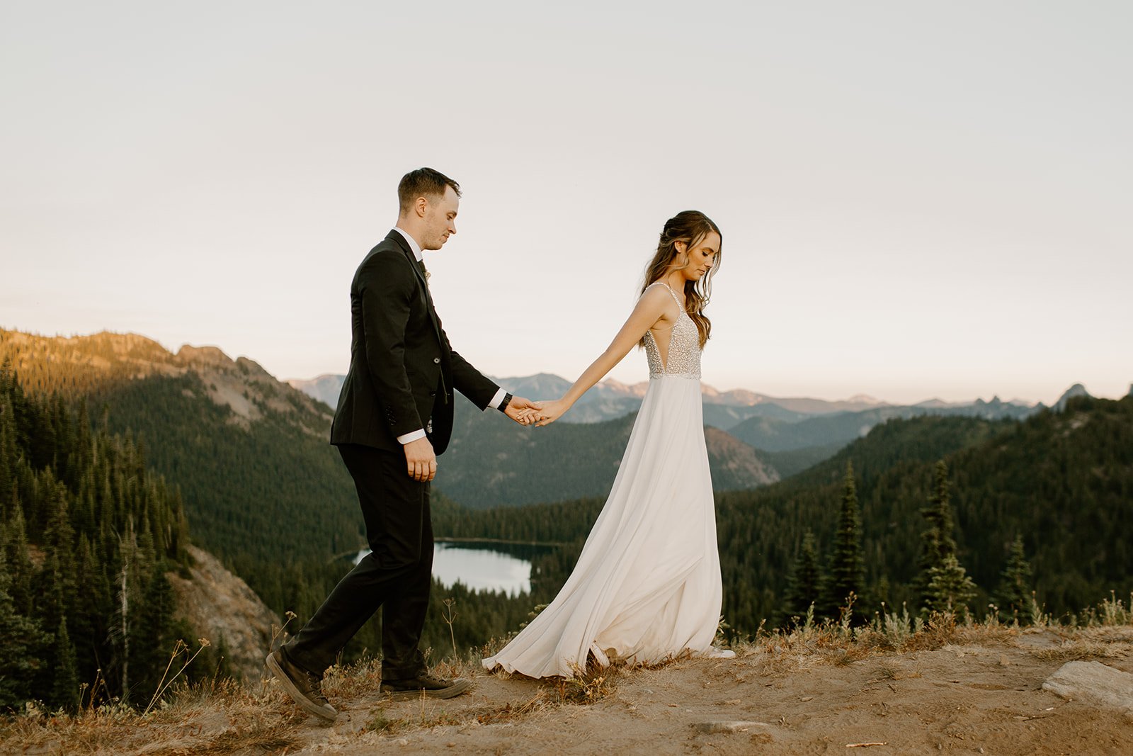 bride and groom walking on a ridge line in mt. rainier