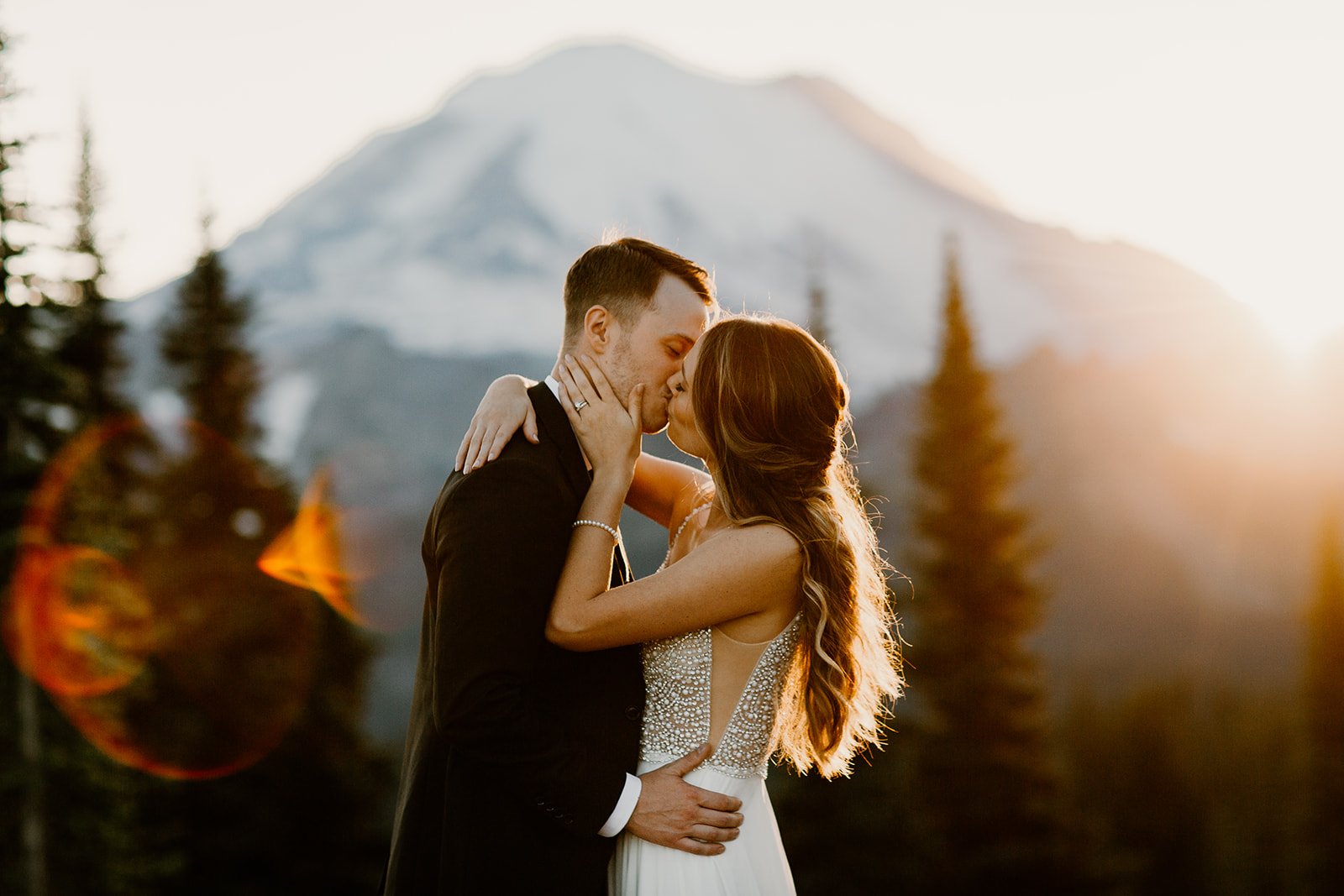bride and groom kissing in front of mt. rainier