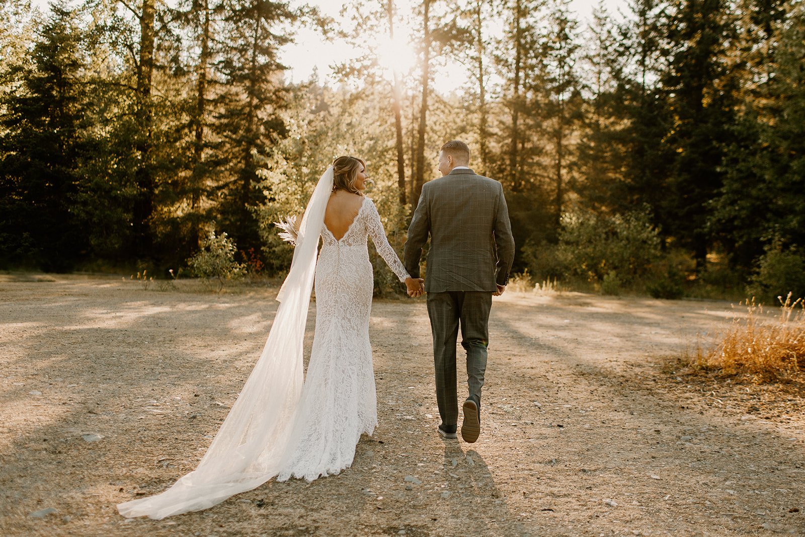 bride and groom walking away from the camera holding hands in their wedding attire in Snoqualmie Pass Washington