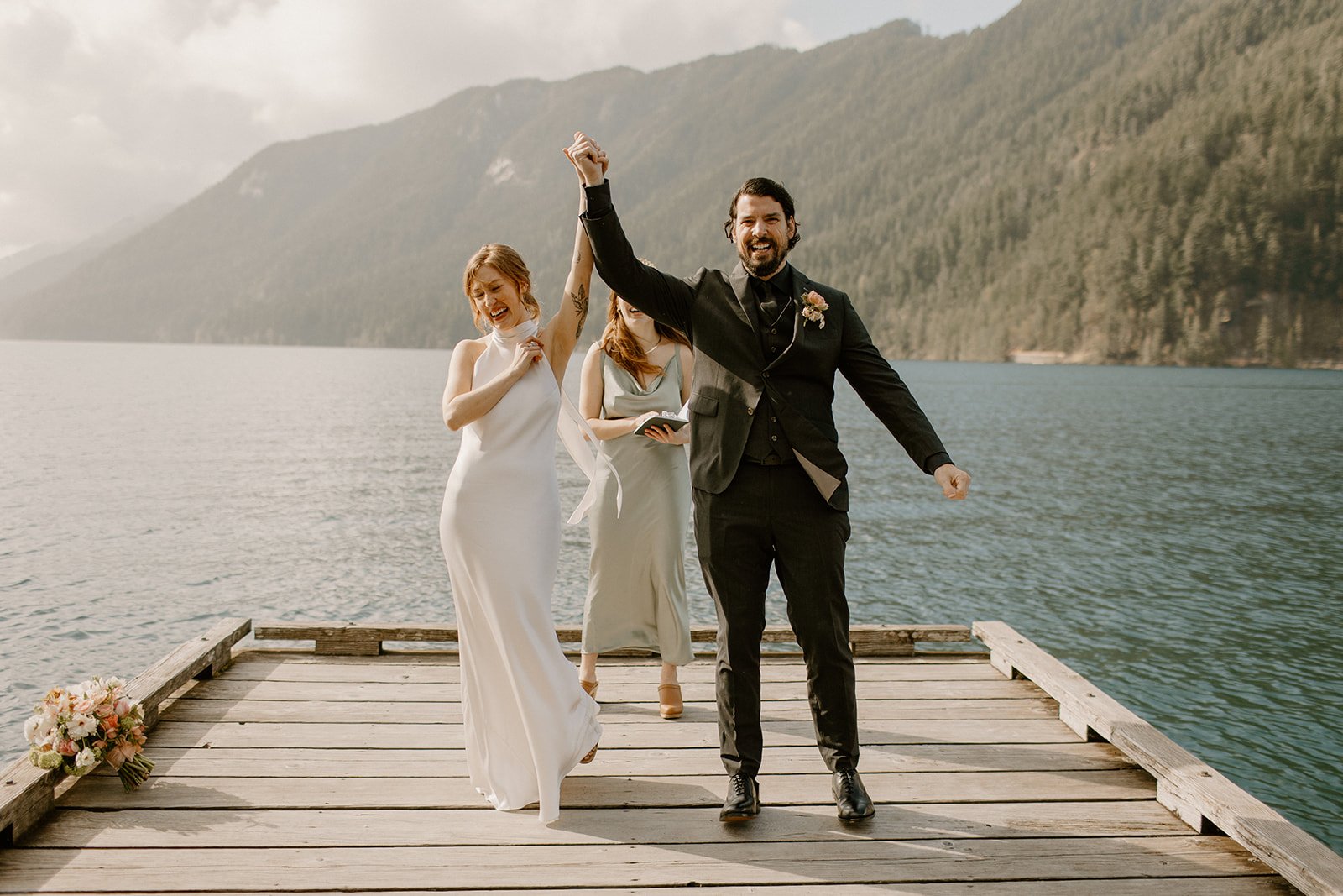 Bride and Groom fist pumping in celebration after their ceremony at Lake Crescent in Washington