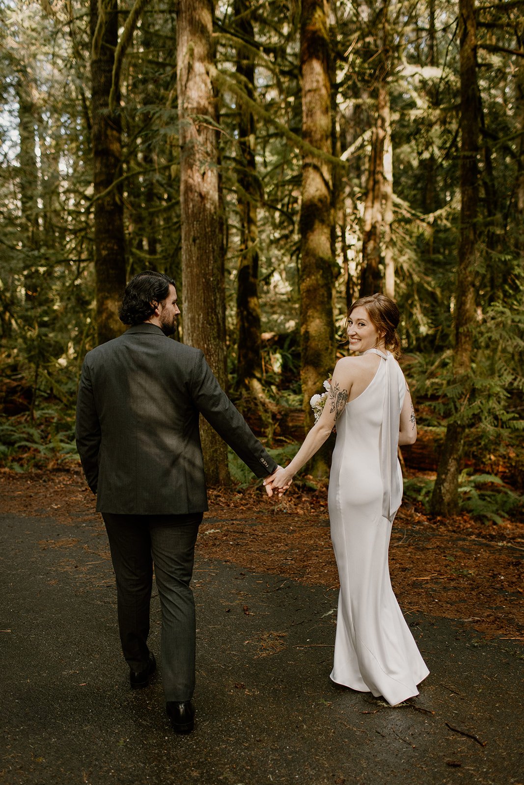 Bride and Groom walking away from the camera in the forest at Olympic NP