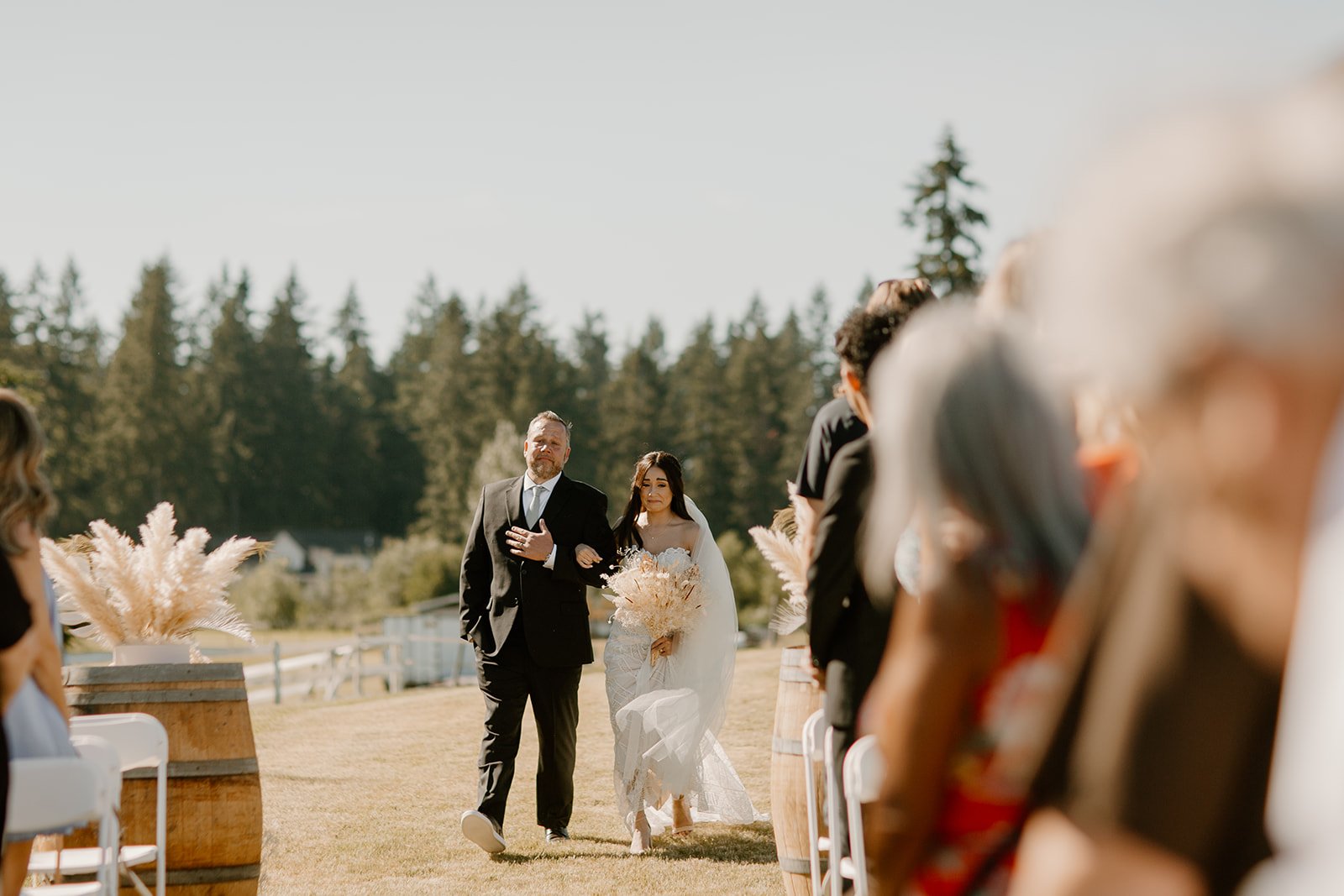 father of the bride walking her down the aisle during their backyard wedding in mount rainier