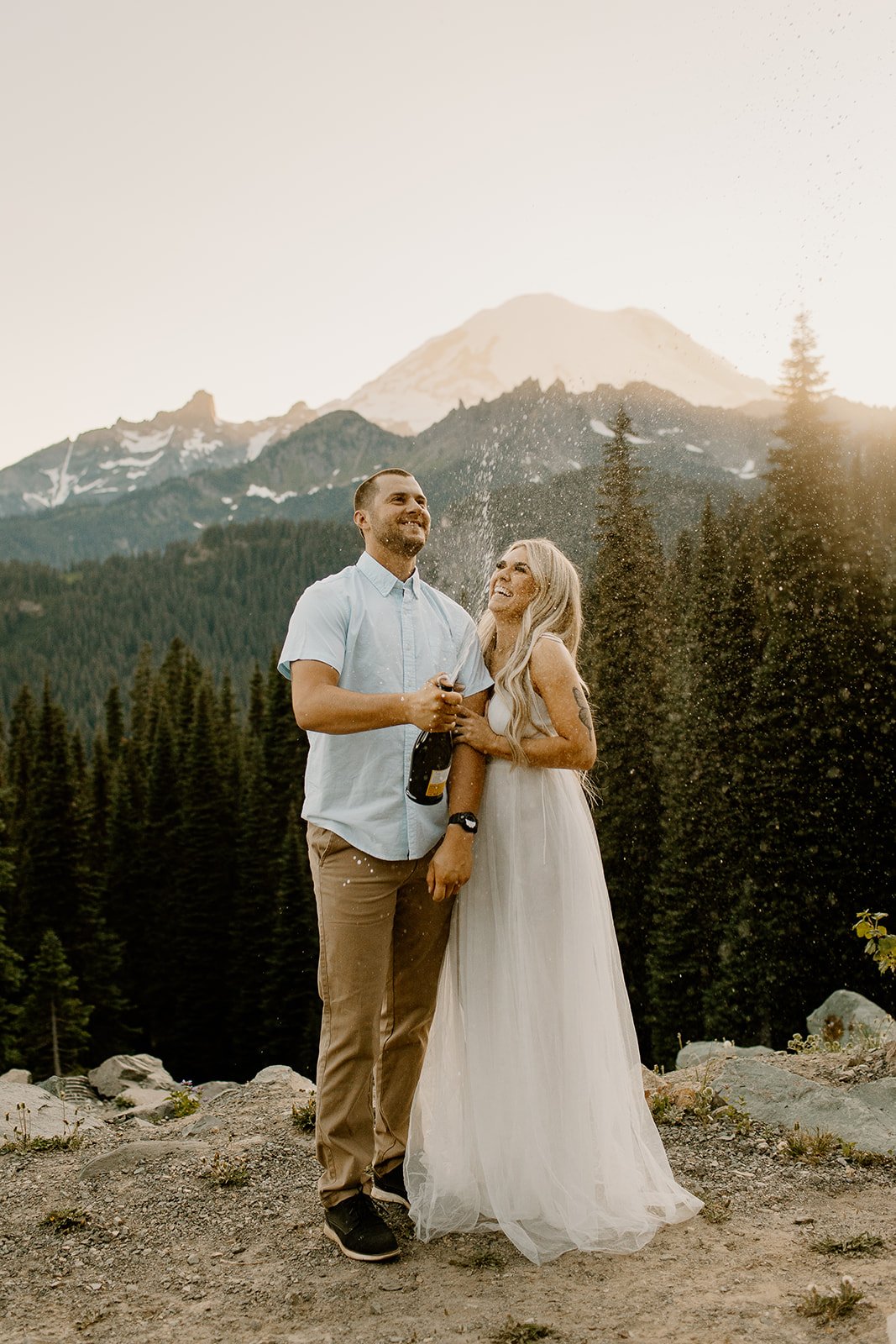 newly engaged couple spray champagne during their engagement session in mt rainier np