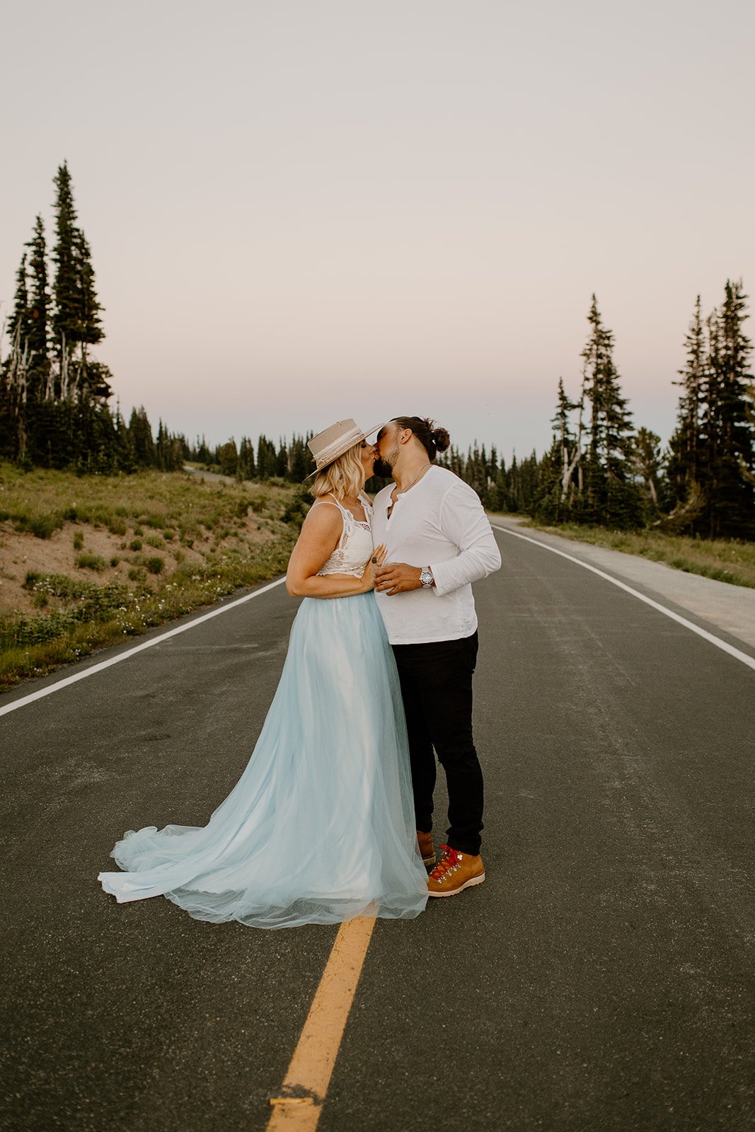 newly engaged couple kissing in the road at mt rainier np