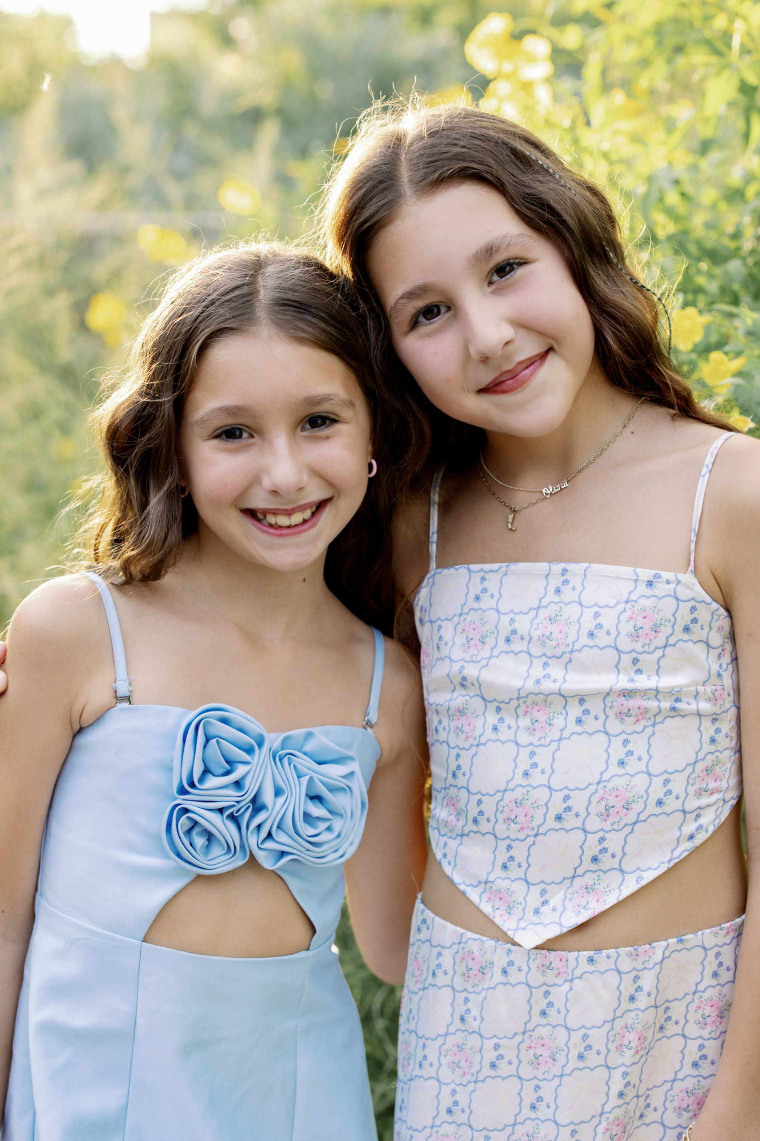 two young girls backlit by the sun in a portrait by melissa glynn
