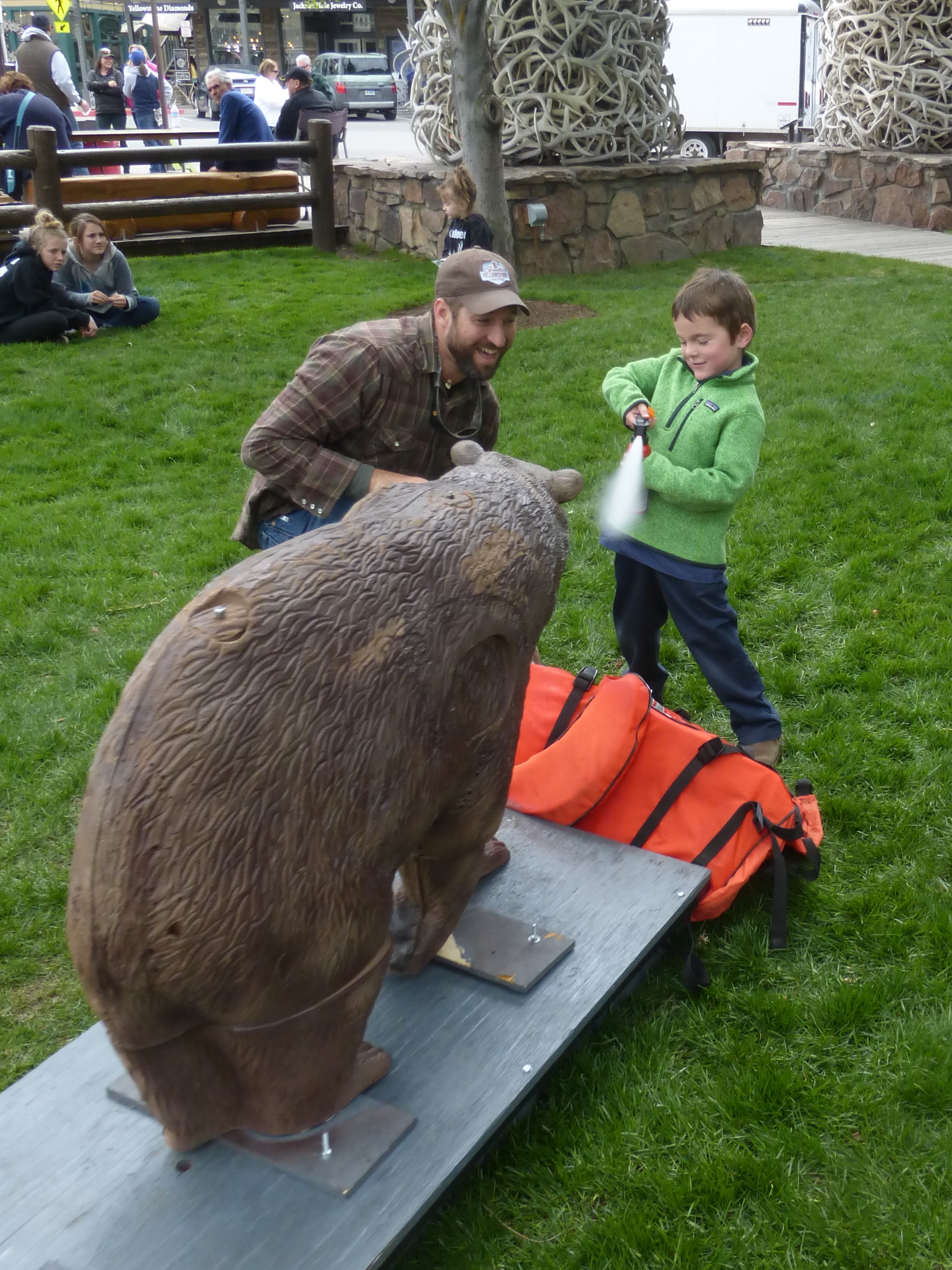 GYC's Chris Colligan helps a young outdoorsman practice his quick-draw bear spray skills. With inert bear spray donated by Counter Assault. (Photo GYC.)