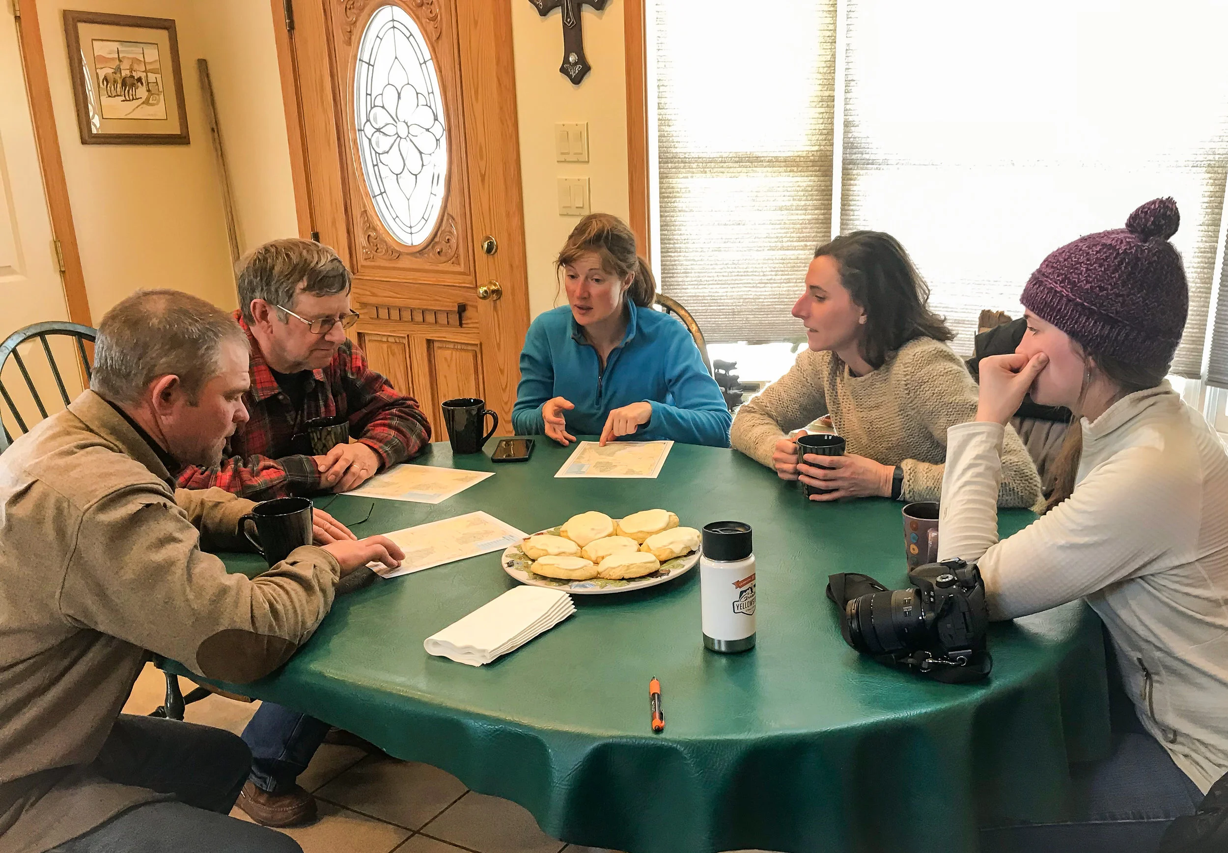 Andy Peterson, John Anderson, Amber Mason, GYC’s Darcie Warden, and GYC’s Brooke Shifrin locate the cattle grazing allotment on a map. (Photo Emmy Reed/GYC.)