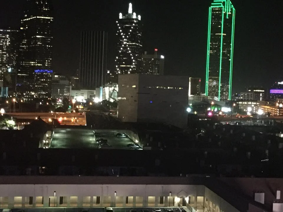 I took this photo Thursday night around 11:30. The cluster of lights beneath the Bank of America building (the one lined in green emerald lights) are police cars blocking access to the standoff.