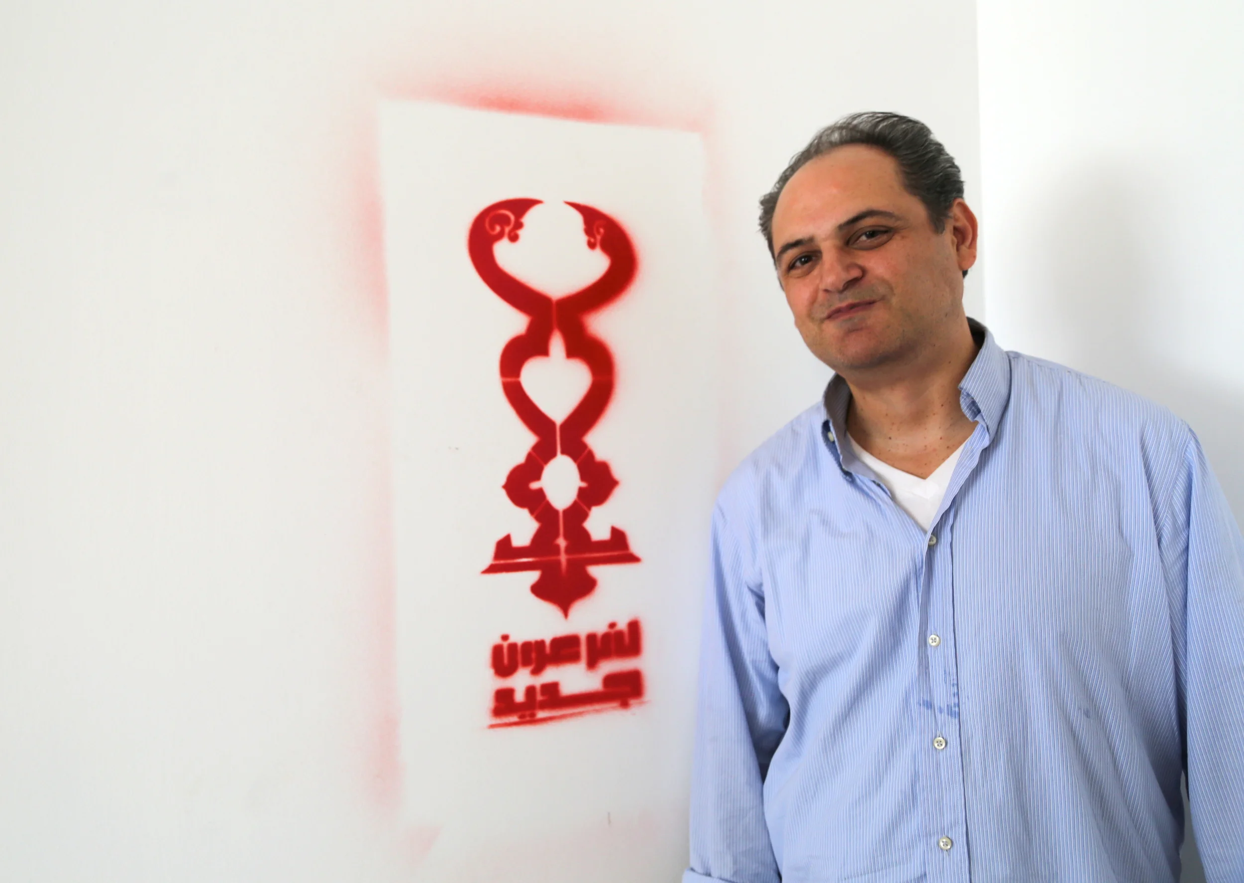  Mark posing next to artist&nbsp; Bahia Shehab's  freshly painted "No to a New Pharaoh" in her 6th of October City art studio, outside of Cairo. 