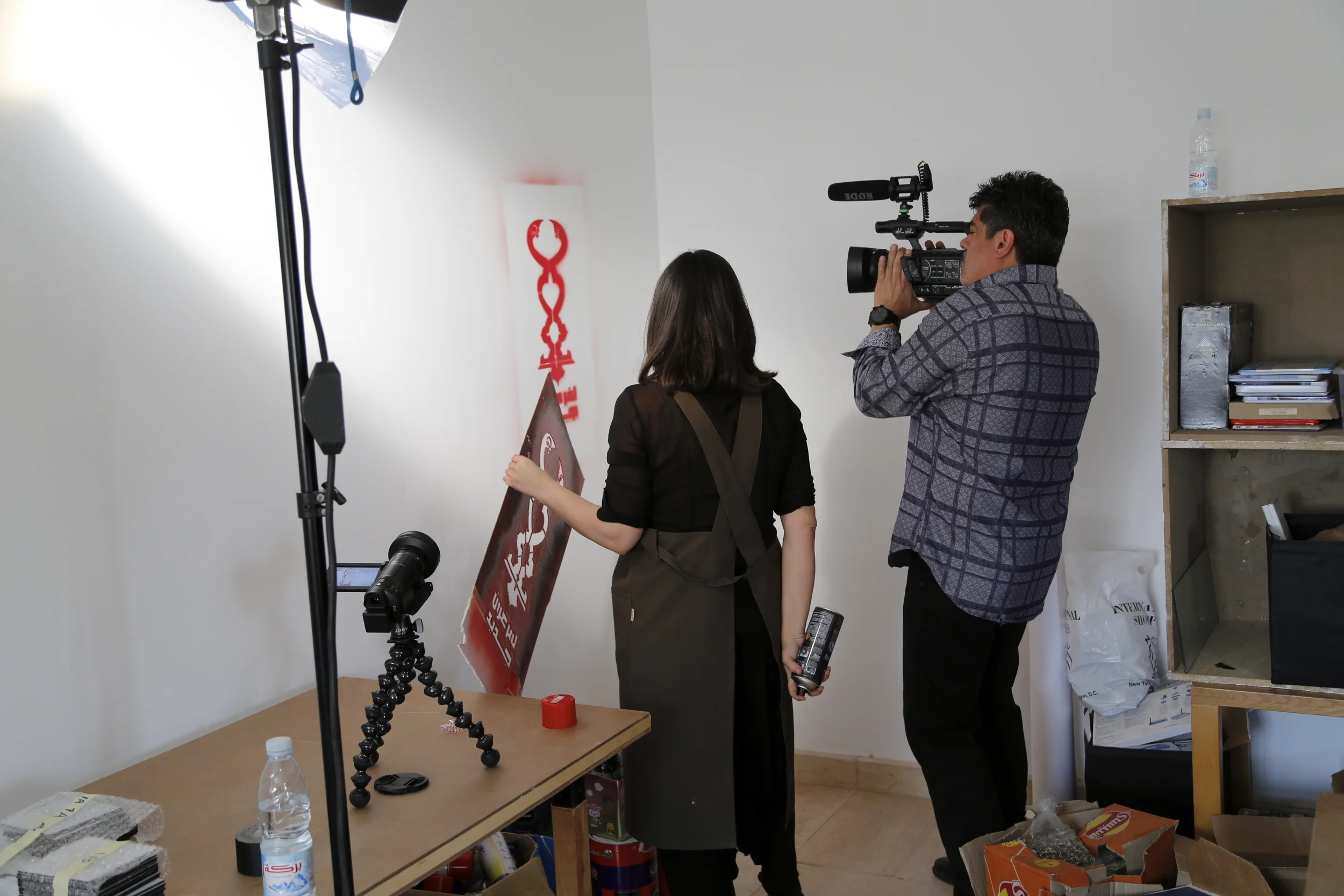  Cinematographer  Oscar Frasser  filming artist  Bahia Shehab's  freshly-painted "No to a New Pharaoh" stencil on the wall of her 6th of October City studio, outside of Cairo. 