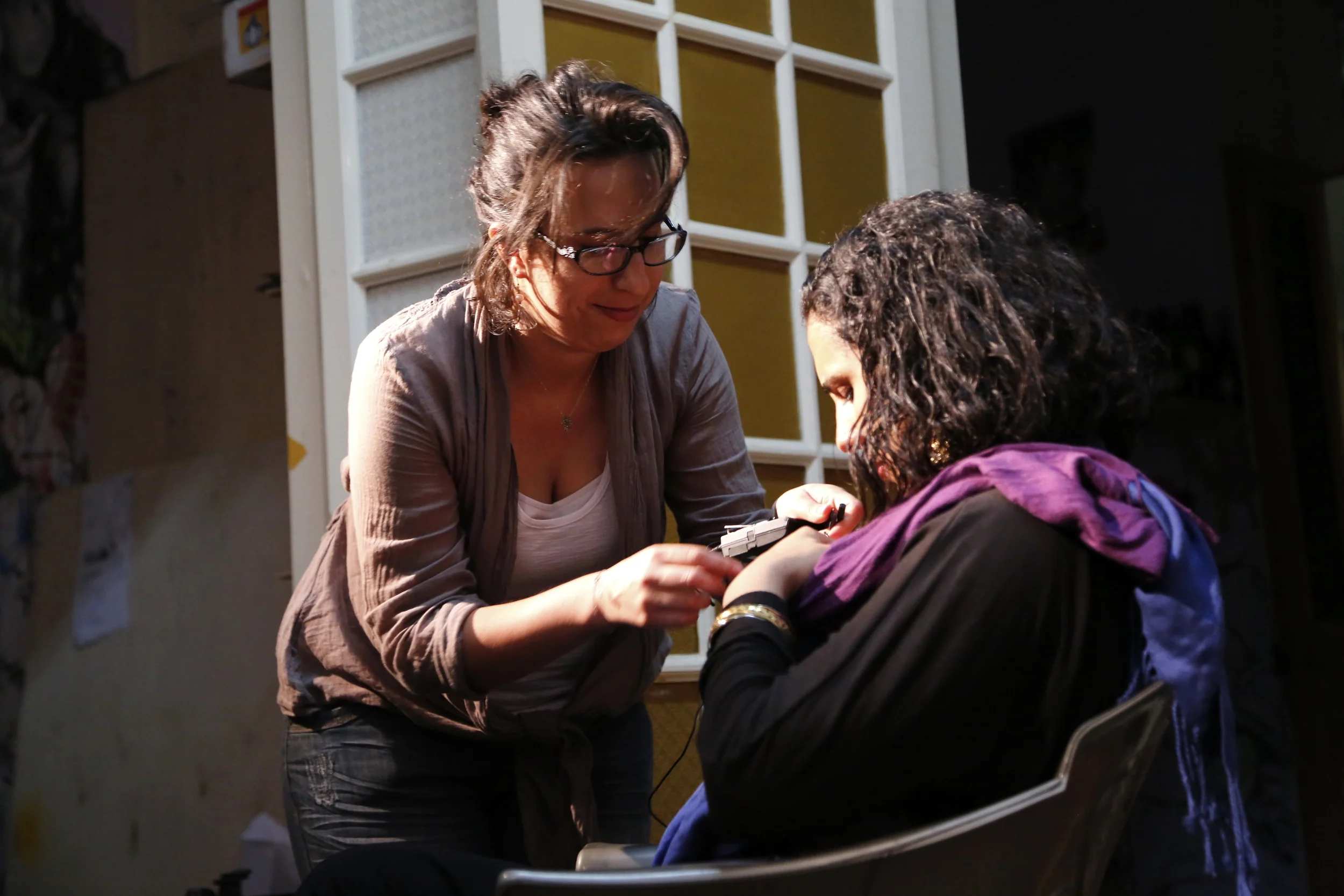  Co-director  Racha Najdi  making adjustments to artist  Salma Samy's  microphone. 