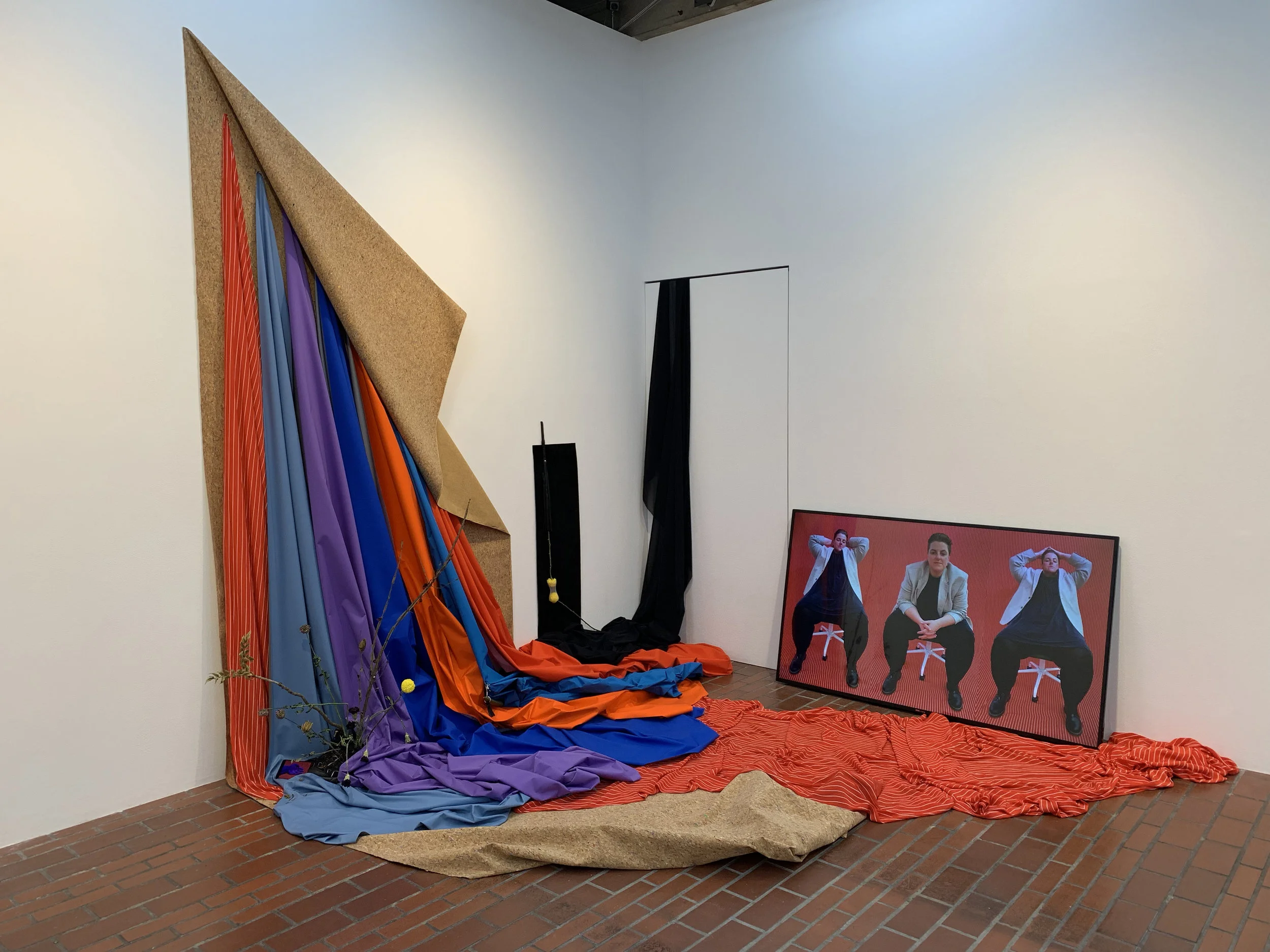 A misunderstanding of what it means to be tender , 2018, Fabric, flowers (chrysanthemum, carnation, holly), leather, whip, shoes, nipple tassel, kenzan, flower net, sansevieria cylindrica, small phone screen playing video of the same title, tv monitor playing video of same title. Commissioned by Move Arts Japan for exhibition at 3331 Arts Chiyoda Gallery, Tokyo, Japan.