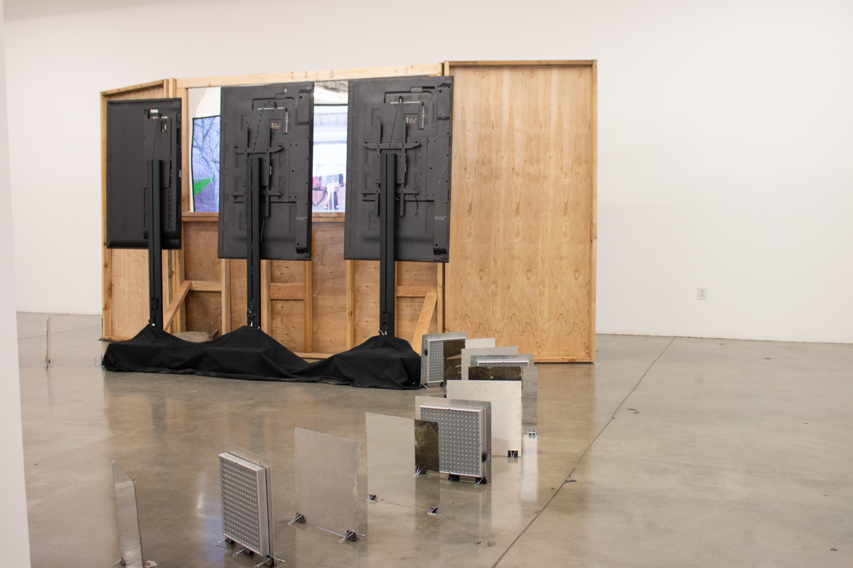 “Untitled Mirage 2, or an Exhibitionary Complex (The Lynda and Stewart Resnick Cultural Center)” Wood Structure, One Way Mirror, Sandbags, Three Channel Video Installation. 2017 work in situ, completed 2018.