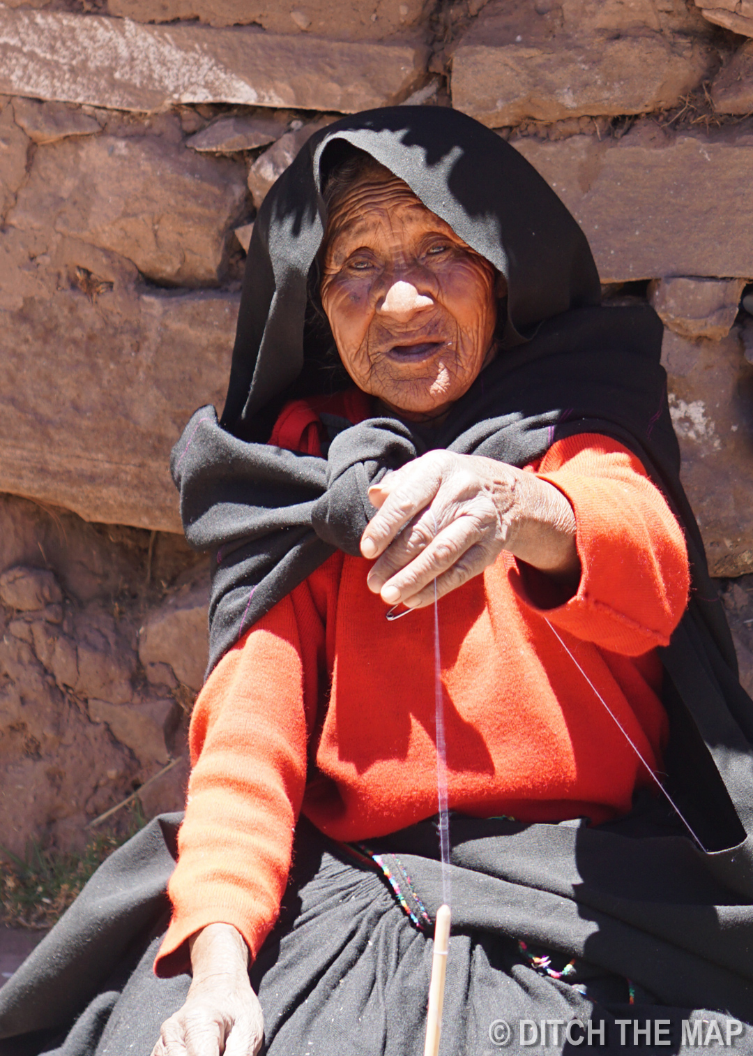 A woman spinning yarn on Taquile Island in Lake Titicaca, Peru