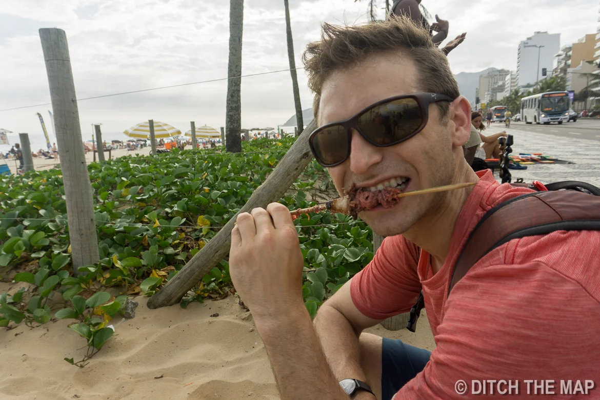 Snacking on some street meat along Ipanema Beach in Rio de Janeiro, Brazil
