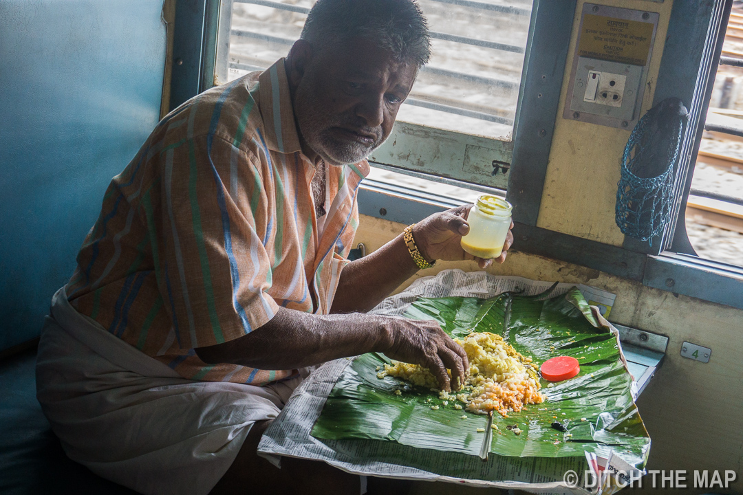 Indian Eating with his Hands on a Train in Kerala, India