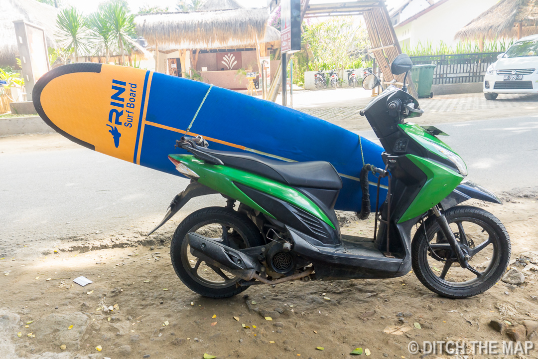 Strapping Surfboard to Scooter in Kuta, Lombok