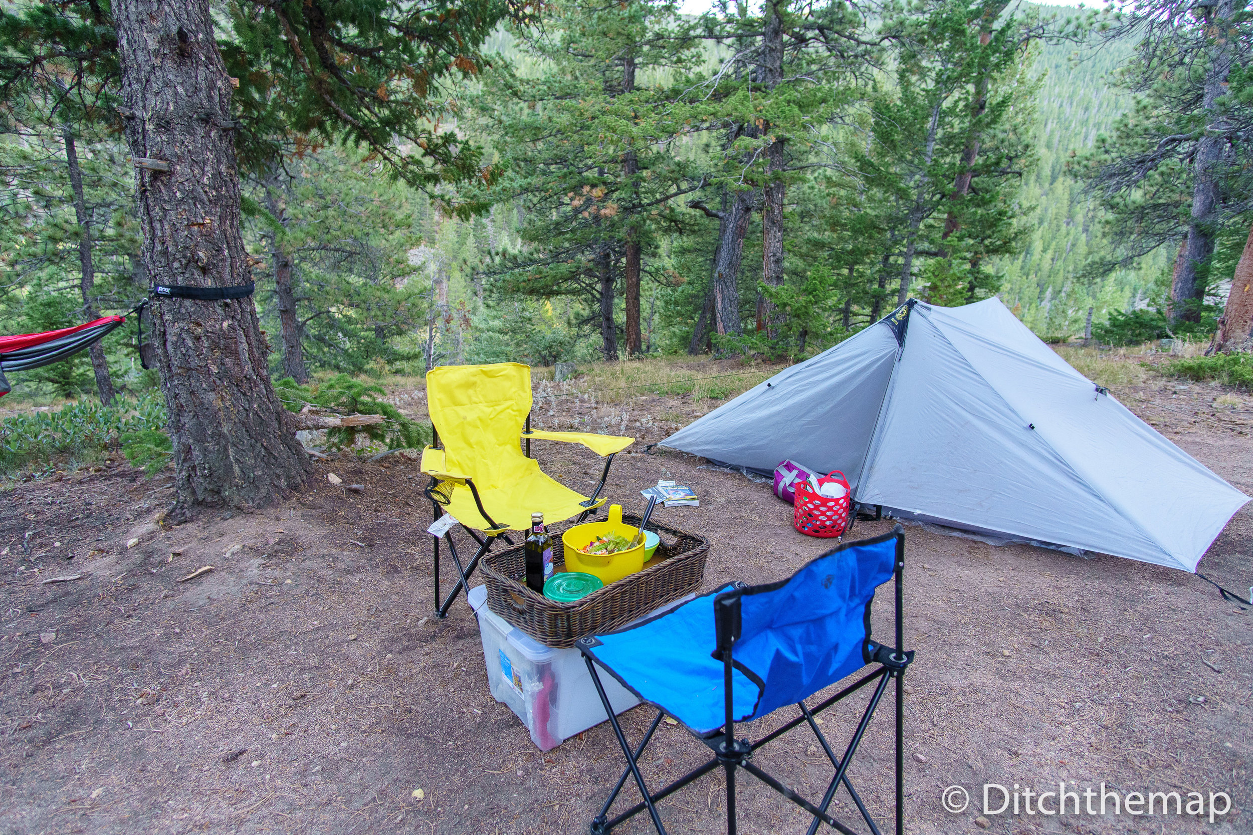 Campsite with tent, hammock, chairs, and dinner all ready