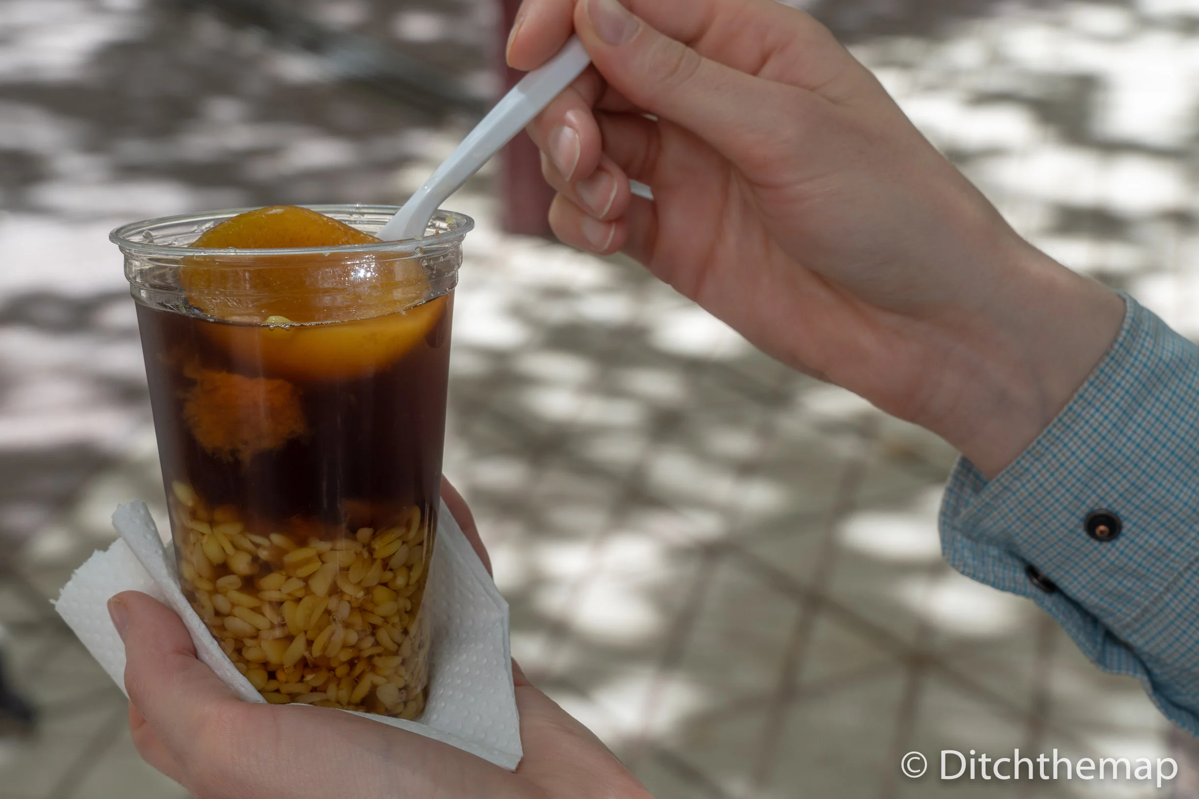 Trying mote con huesillo a sweet and syrupy peach drink with hulled wheat in Santiago, Chile