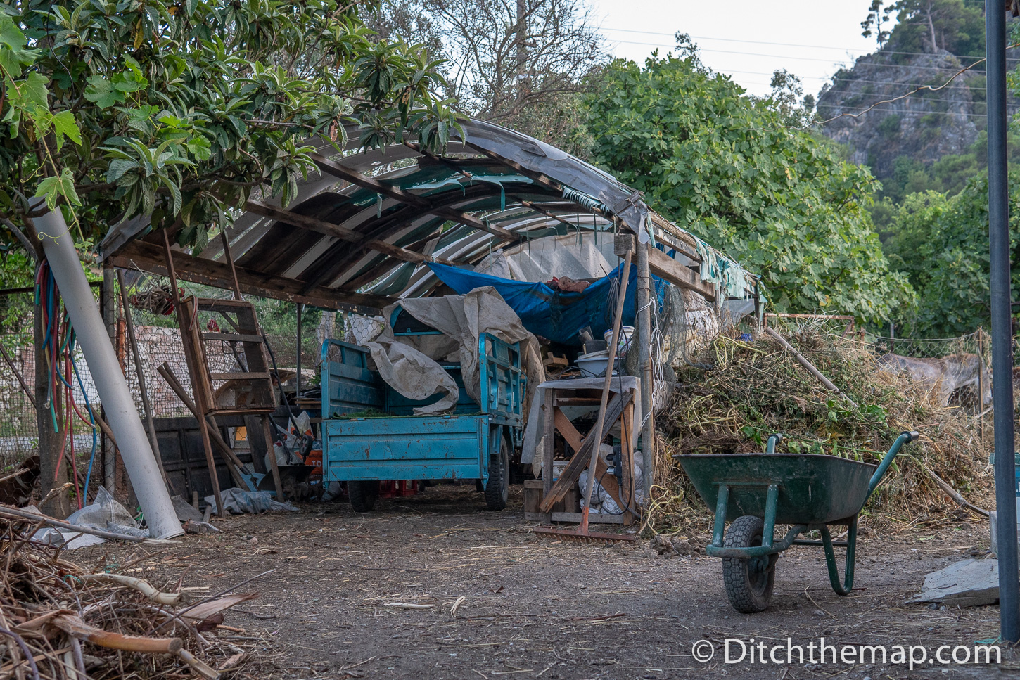 Wheelbarrow and truck on farm