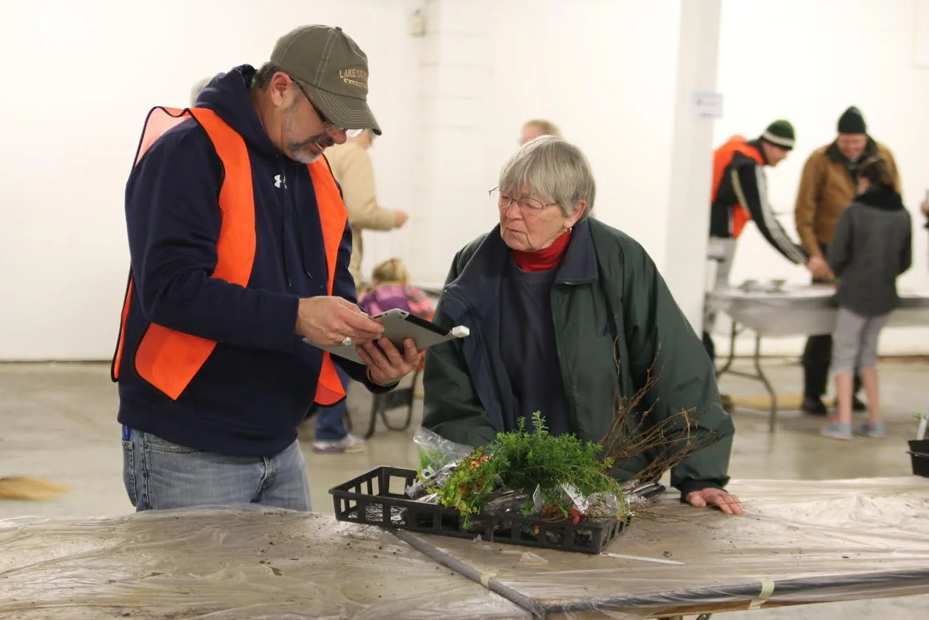 Photo of Board Chair, Mark Craven, and a plant sale customer