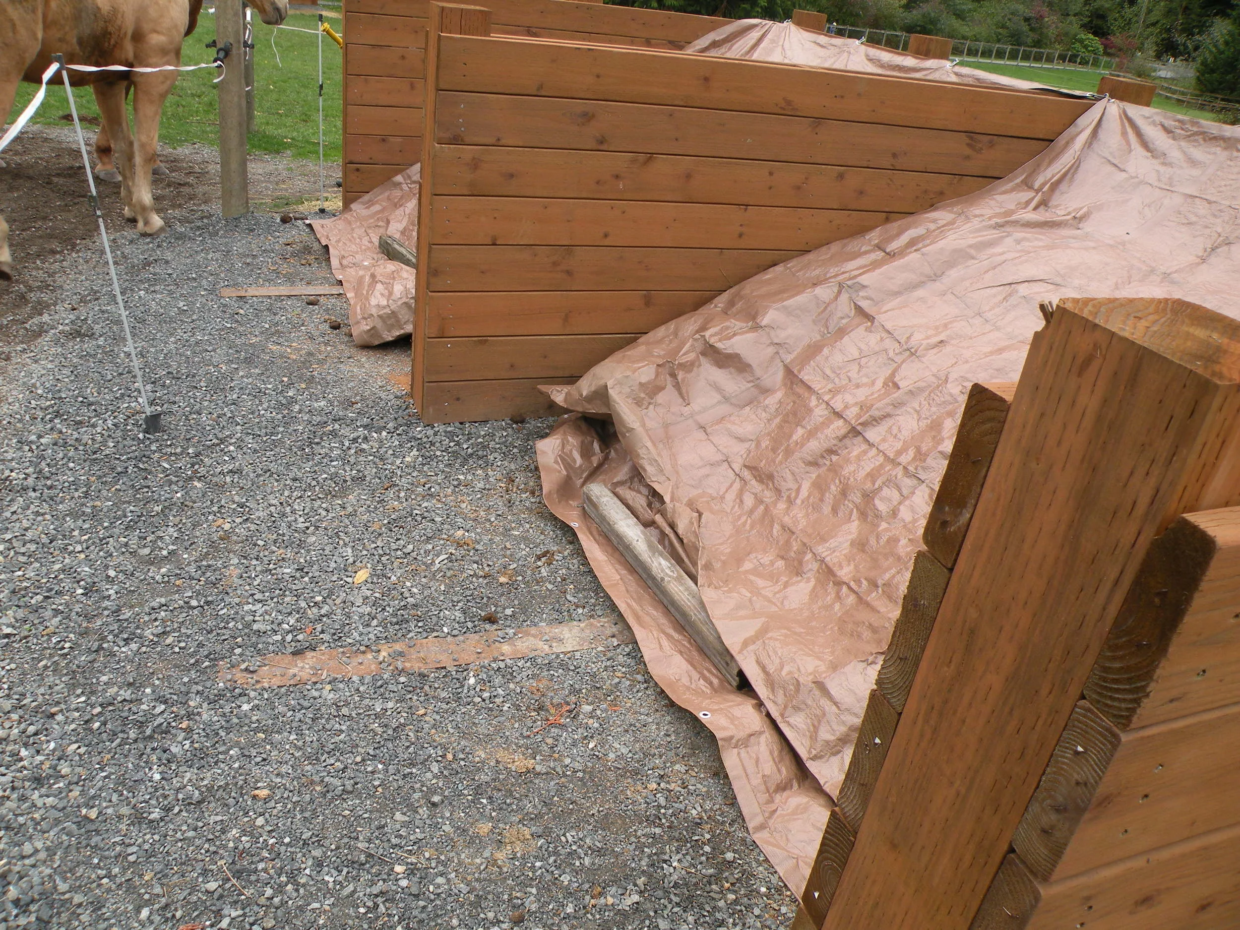Covering your manure piles can be as easy as adding tarps and weighing them down with boards or bricks. 