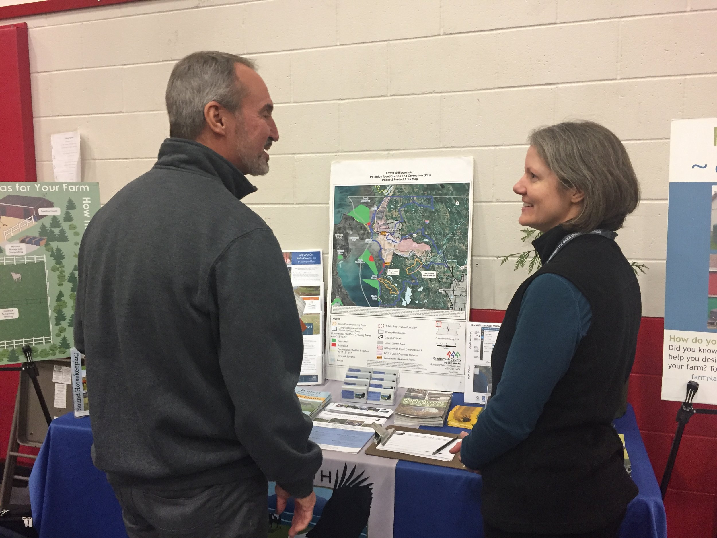 Kathryn talking to a booth participant about the Stillaguamish PIC