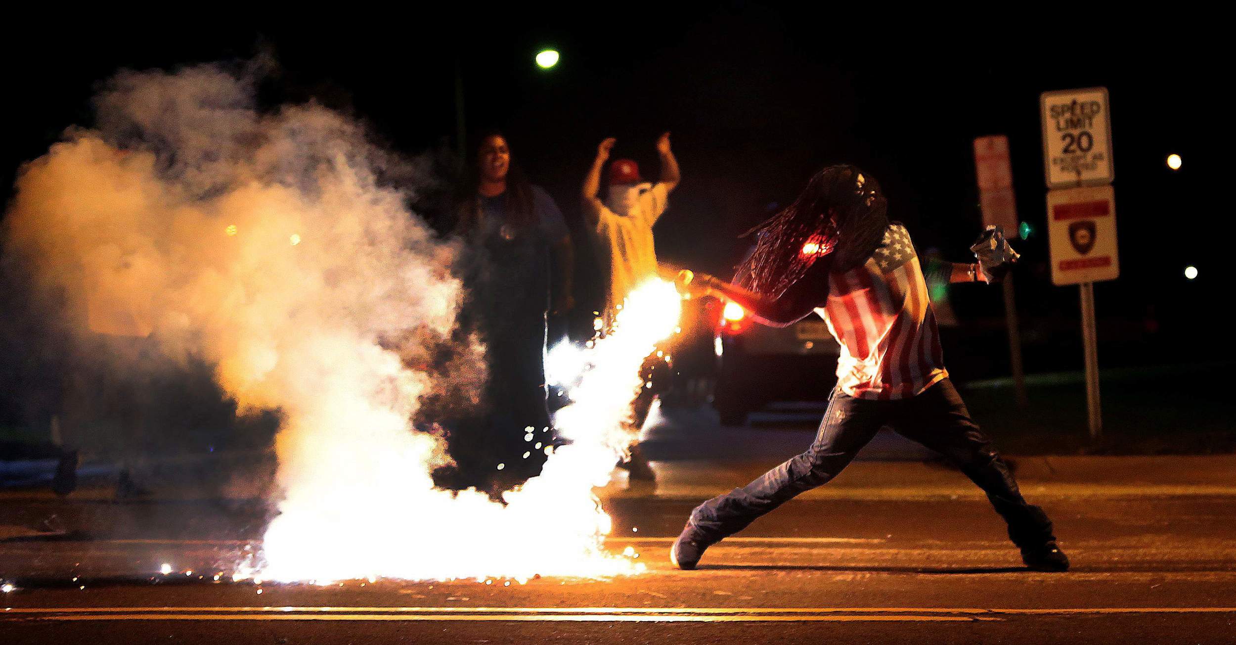 A protester in Ferguson throwing back a can of tear gas deployed by police during a peaceful demonstration. Photo: Associated Press