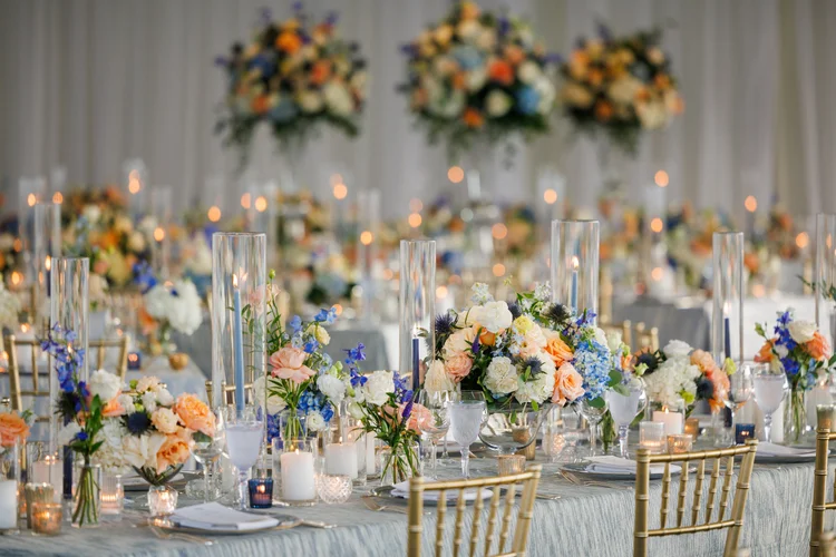 Reception tables with arrangements in white, peach, blue and green at Sleepy Hollow