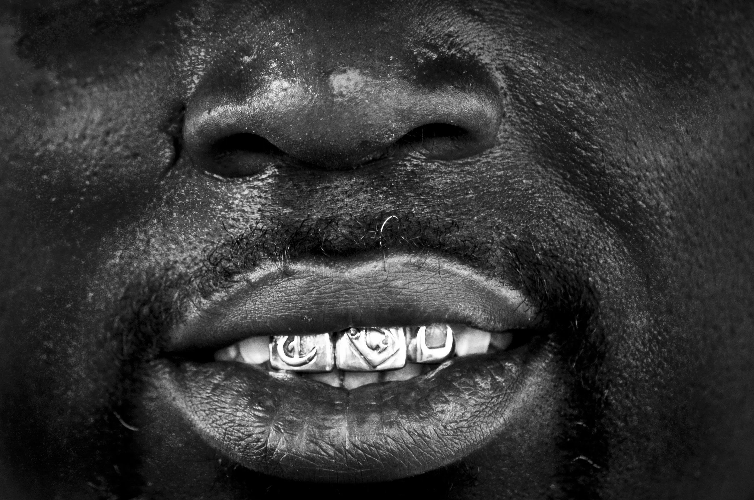 Tyrone Jackson shows off his gold teeth outside of his business North Side Audio in North Tulsa. Many of the small businesses in North Tulsa struggle to stay open due to the violence and poverty that plagues the area. Nick Oxford for The New York Times