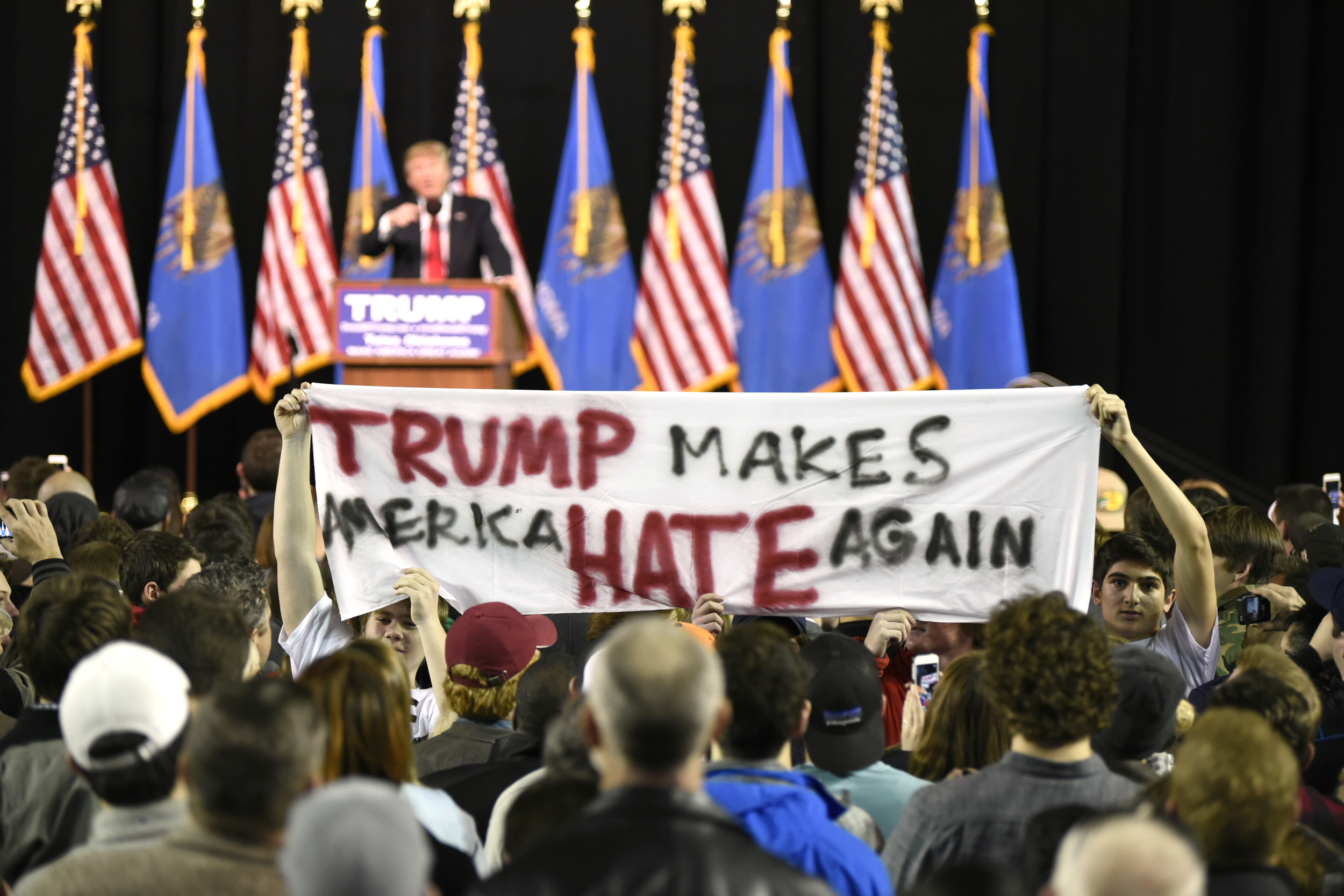   Protestors hold up a sign towards the crowd at a rally for U.S. Republican presidential candidate Donald Trump at Oral Roberts University in Tulsa, Oklahoma, January 20, 2016. REUTERS/Nick Oxford  