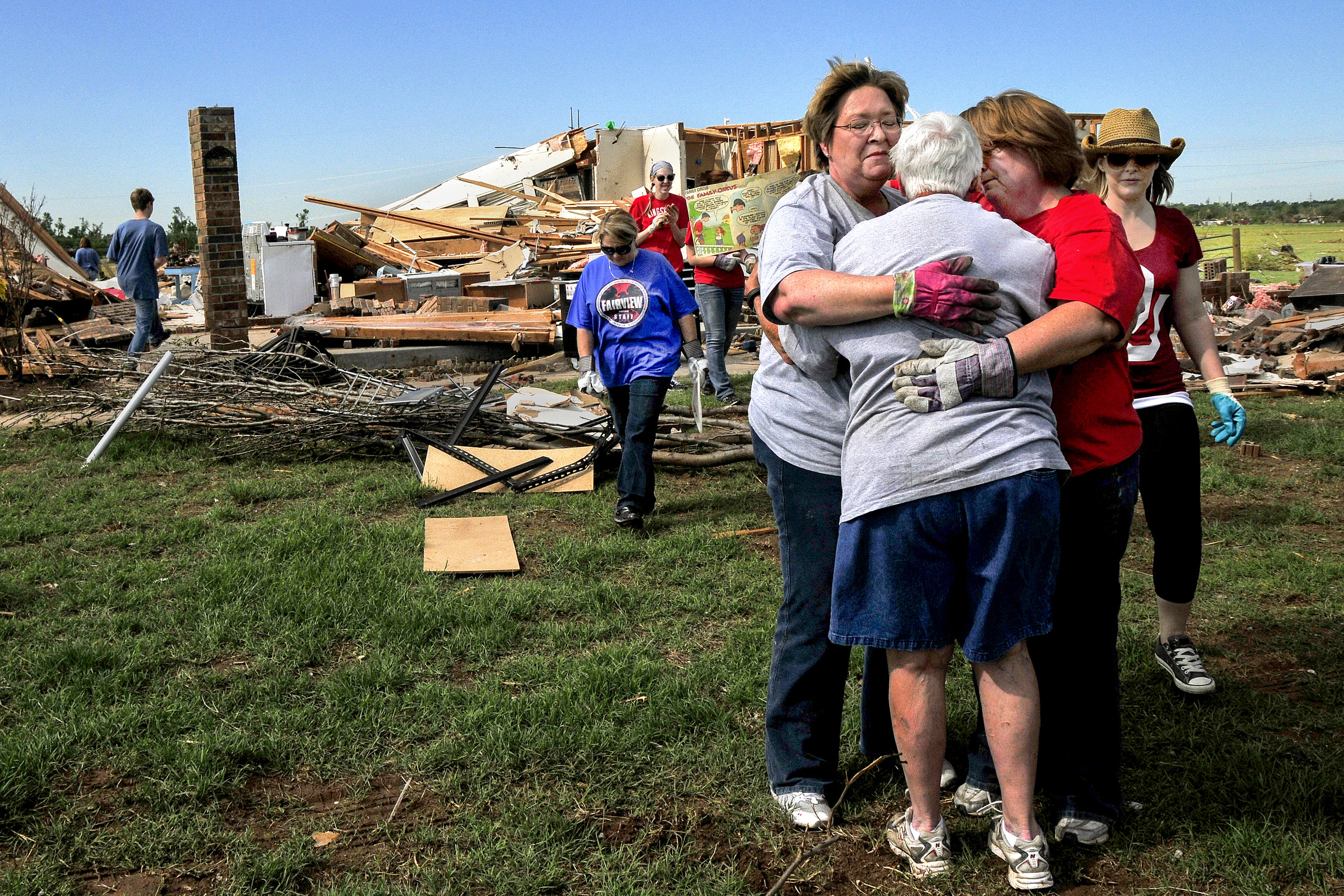  Teachers from Fairview Elementary school embrace former school counselor Kay Johnson, center, in front of her home in a neighborhood that was in the direct path of Mondays Tornado on Wednesday May, 22 in South Oklahoma City just west of Moore. The p