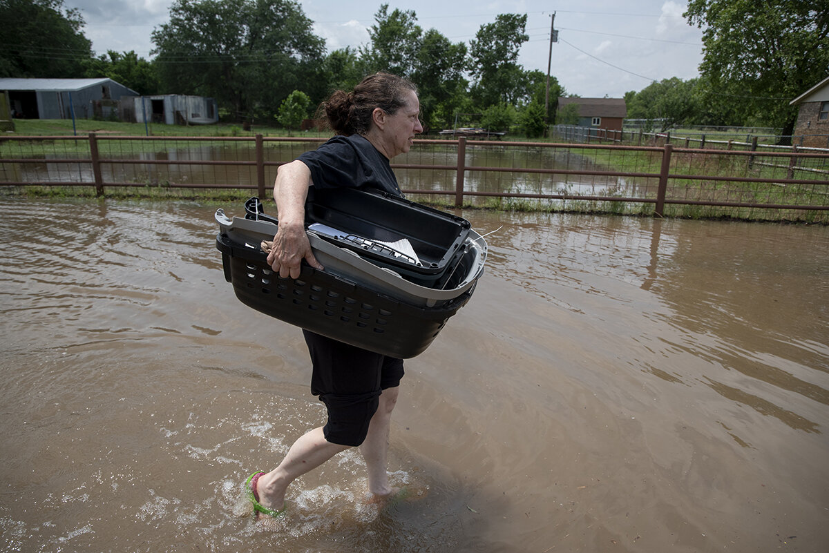  Debbie Giles wades through floodwater from the Arkansas River to rescue her cats from her home in Sand Springs, Oklahoma. Nick Oxford for The New York Times 