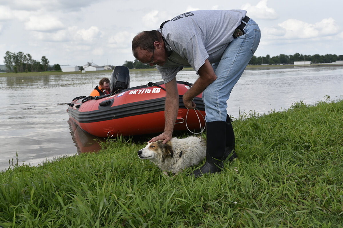  Philip Blair comforts a dog that was rescued from floodwaters in Webber's Falls, Oklahoma. 