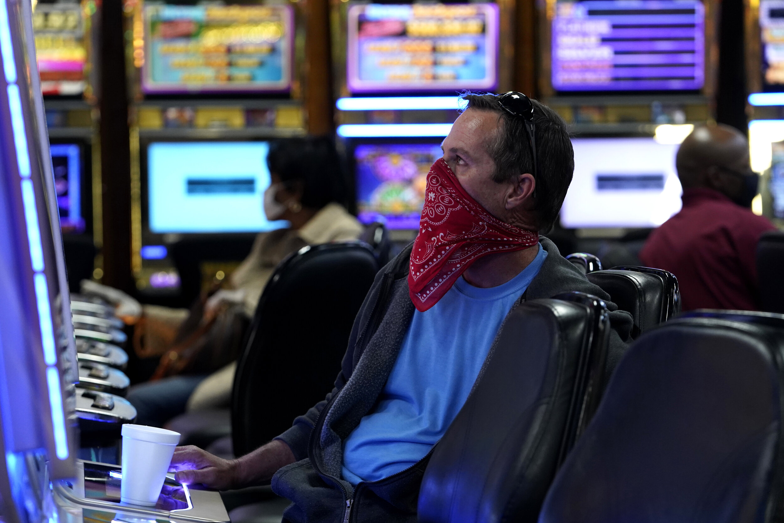  A man wearing a bandana plays a slot machine at the recently reopened Lucky Star Casino amid the spread of the coronavirus disease (COVID-19), in El Reno, Oklahoma, U.S. May 20, 2020. REUTERS/Nick Oxford 