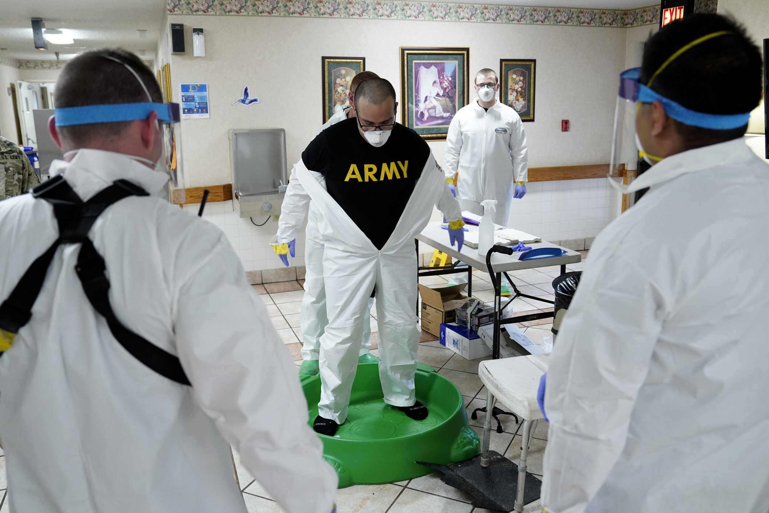  An Oklahoma National Guardsman has his PPE removed after a decontamination mission at a longterm care facility amid the spread of coronavirus disease (COVID-19) in McAlester, Oklahoma, U.S. April 22, 2020. REUTERS/Nick Oxford 