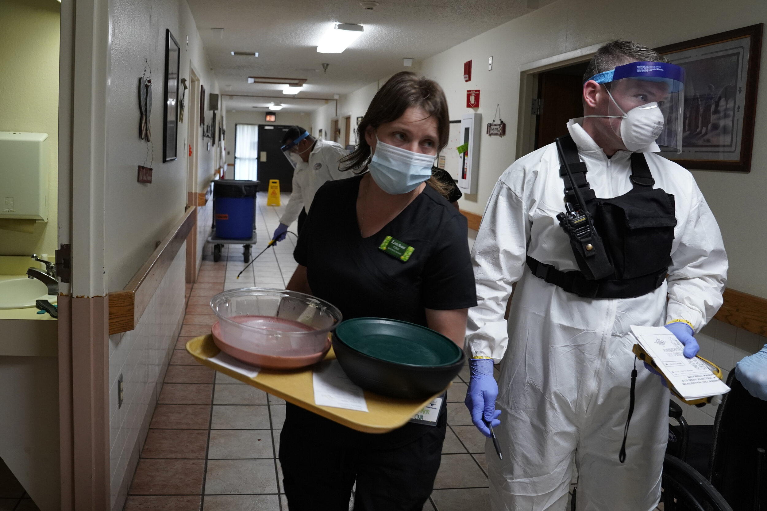  A nurse passes by an Oklahoma National Guardsman during a decontamination mission at a longterm care facility amid the spread of coronavirus disease (COVID-19) in McAlester, Oklahoma, U.S. April 22, 2020. REUTERS/Nick Oxford 