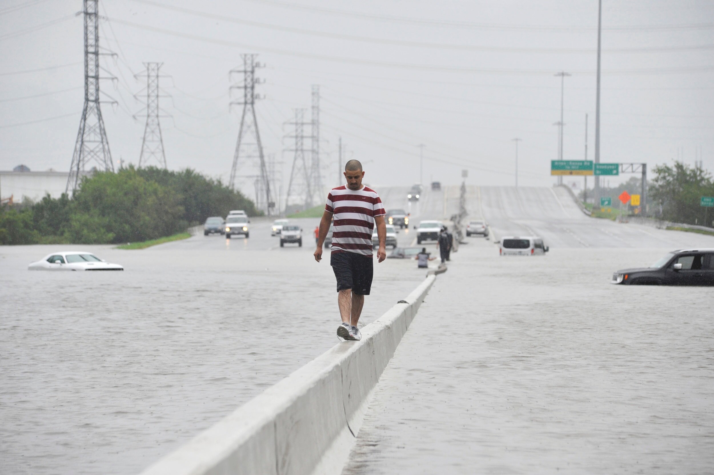  A stranded motorist escapes floodwaters on Interstate 225 after Hurricane Harvey inundated the Texas Gulf coast with rain causing mass flooding, in Houston, Texas, U.S. August 27, 2017.  REUTERS/Nick Oxford 