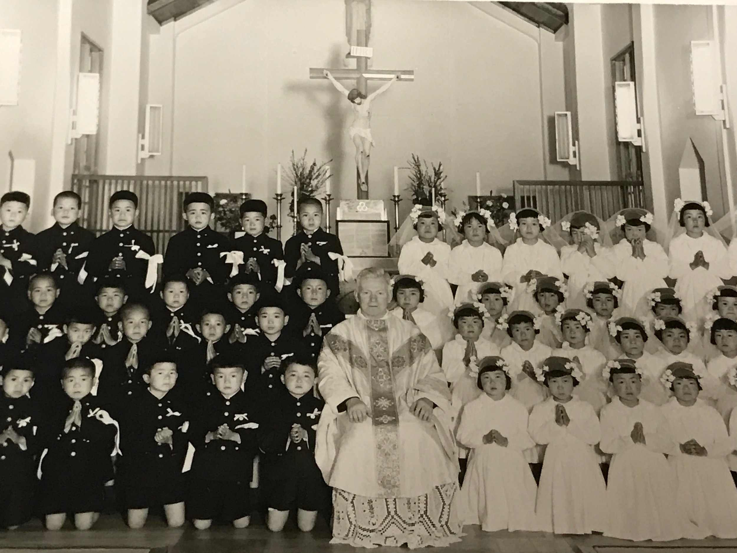 Father Purcell with Japanese children. Boys and girls were always seated on opposite sides of the church.