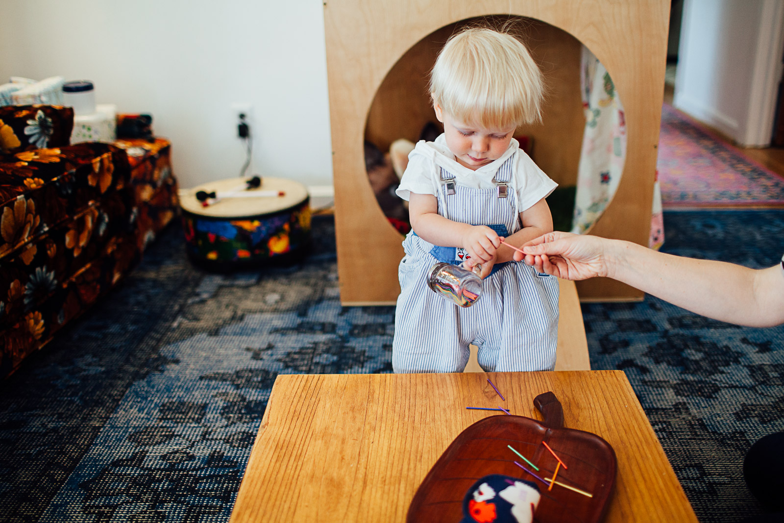 Toddler playing with colored sticks at home