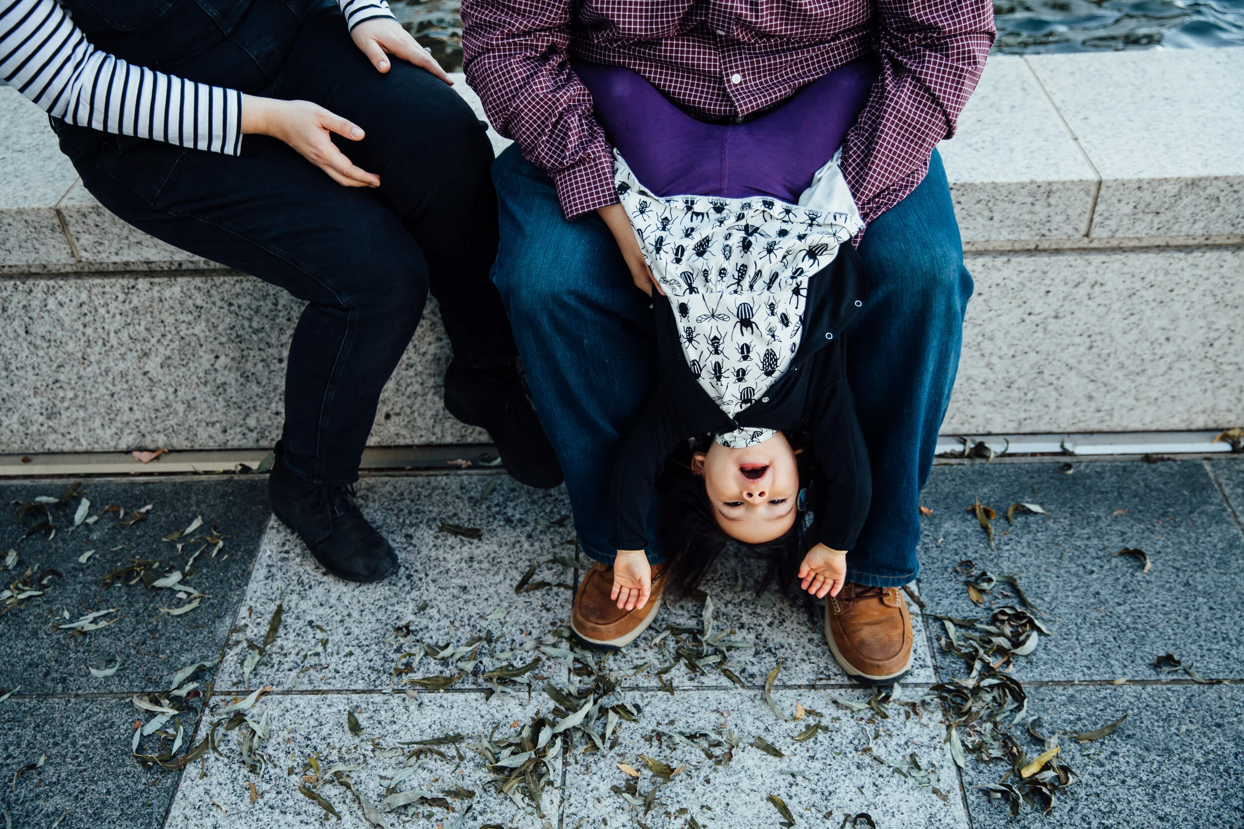 girl upside down on her dad's lap.jpg