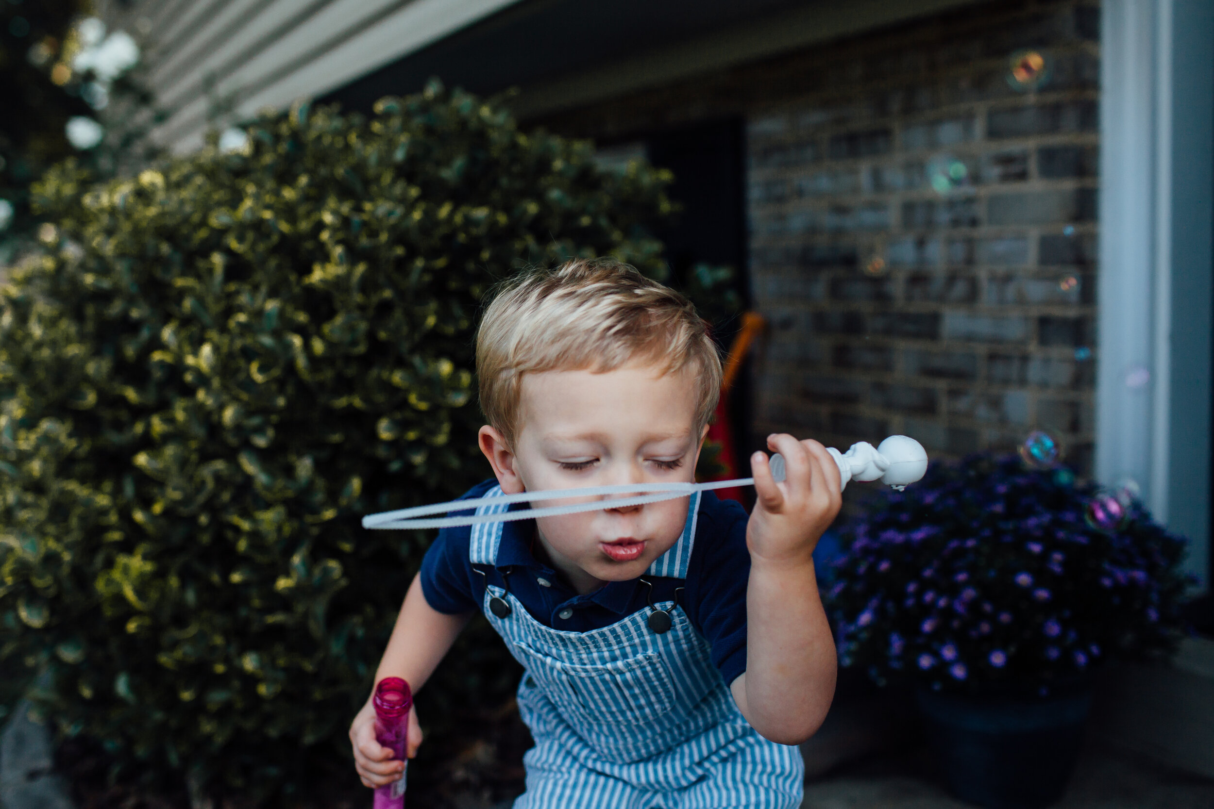 toddler blowing bubbles in a romper.jpg