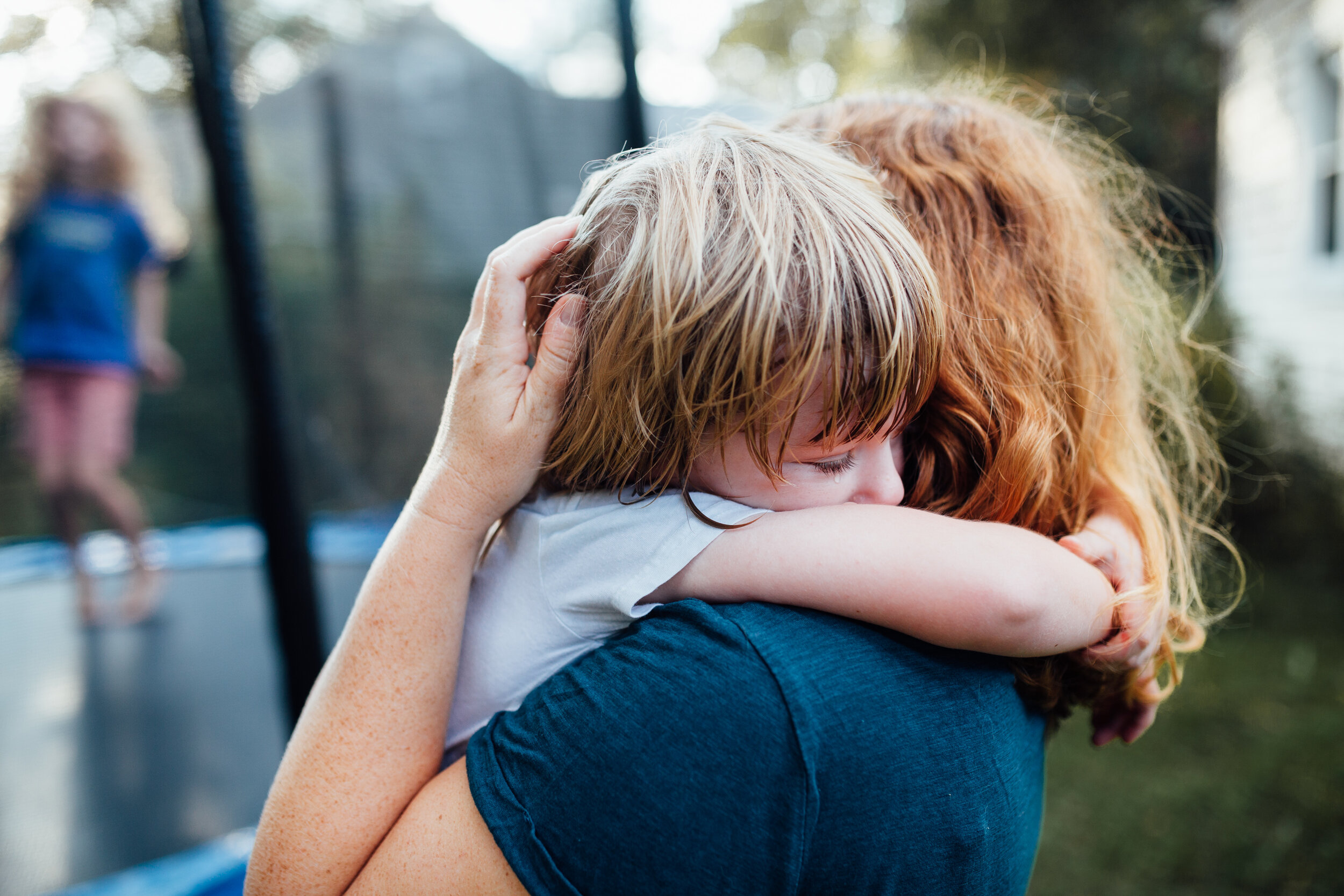 boy seeking comfort in mom's arms.jpg