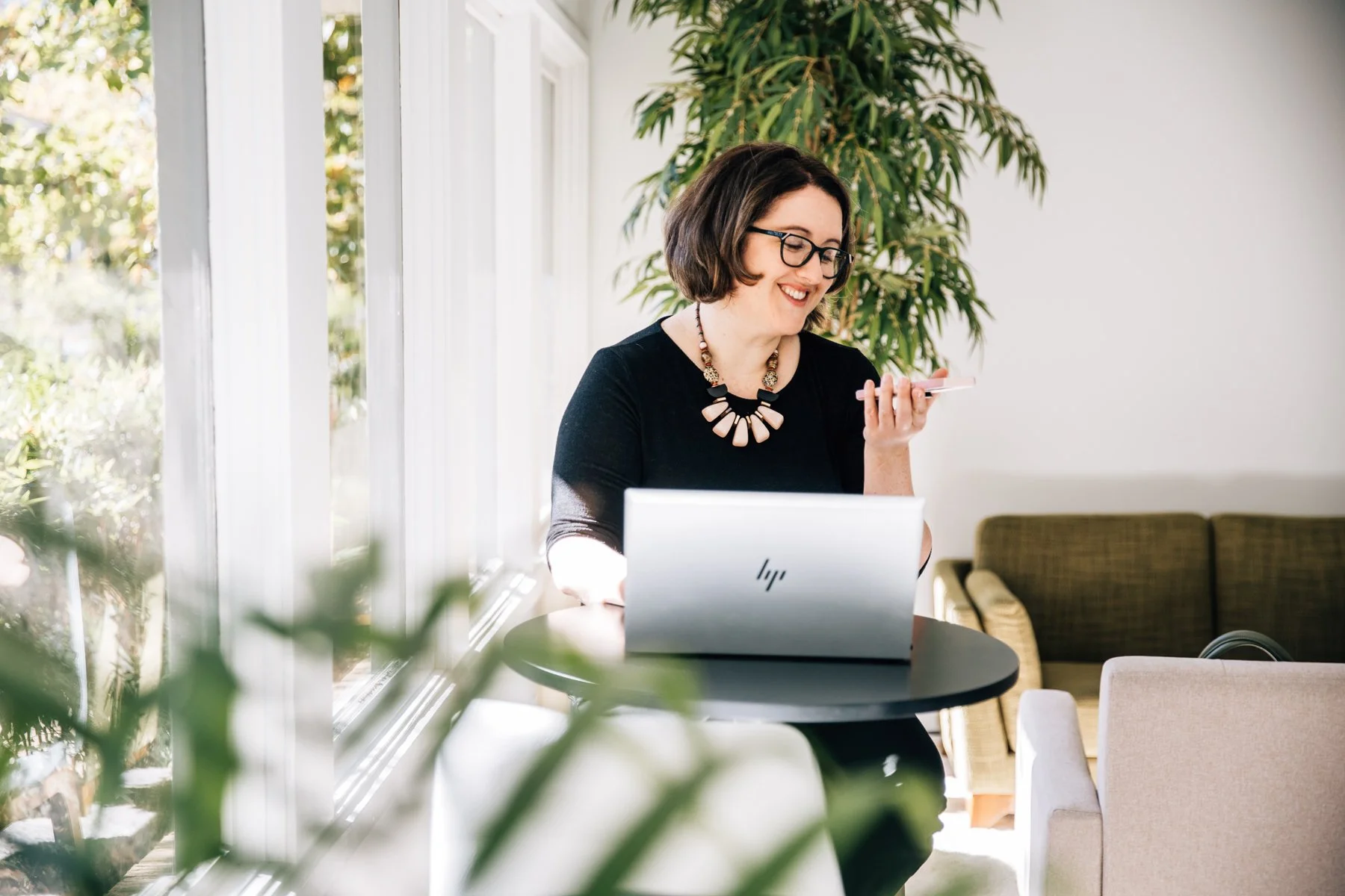 entrepreneur talking to her phone in front of her laptop
