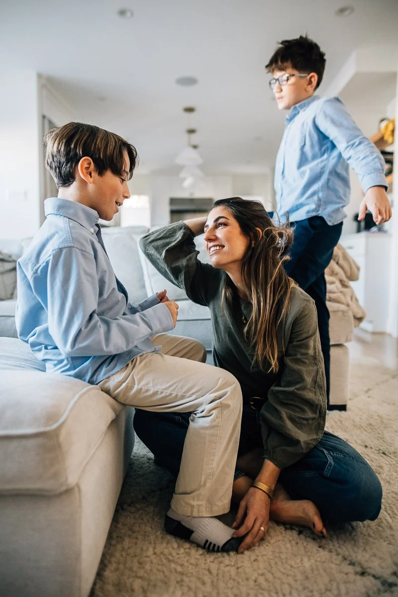 mom sitting on the floor with her teen boys