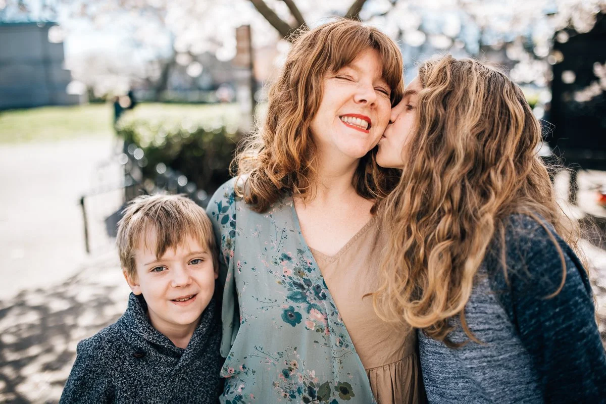 mother being kissed on the cheek by her teenage boy