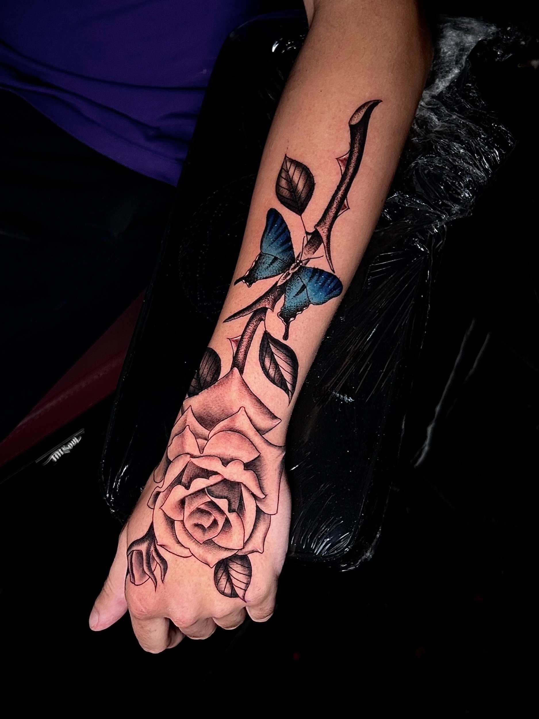 rose on the hand with blue butterfly